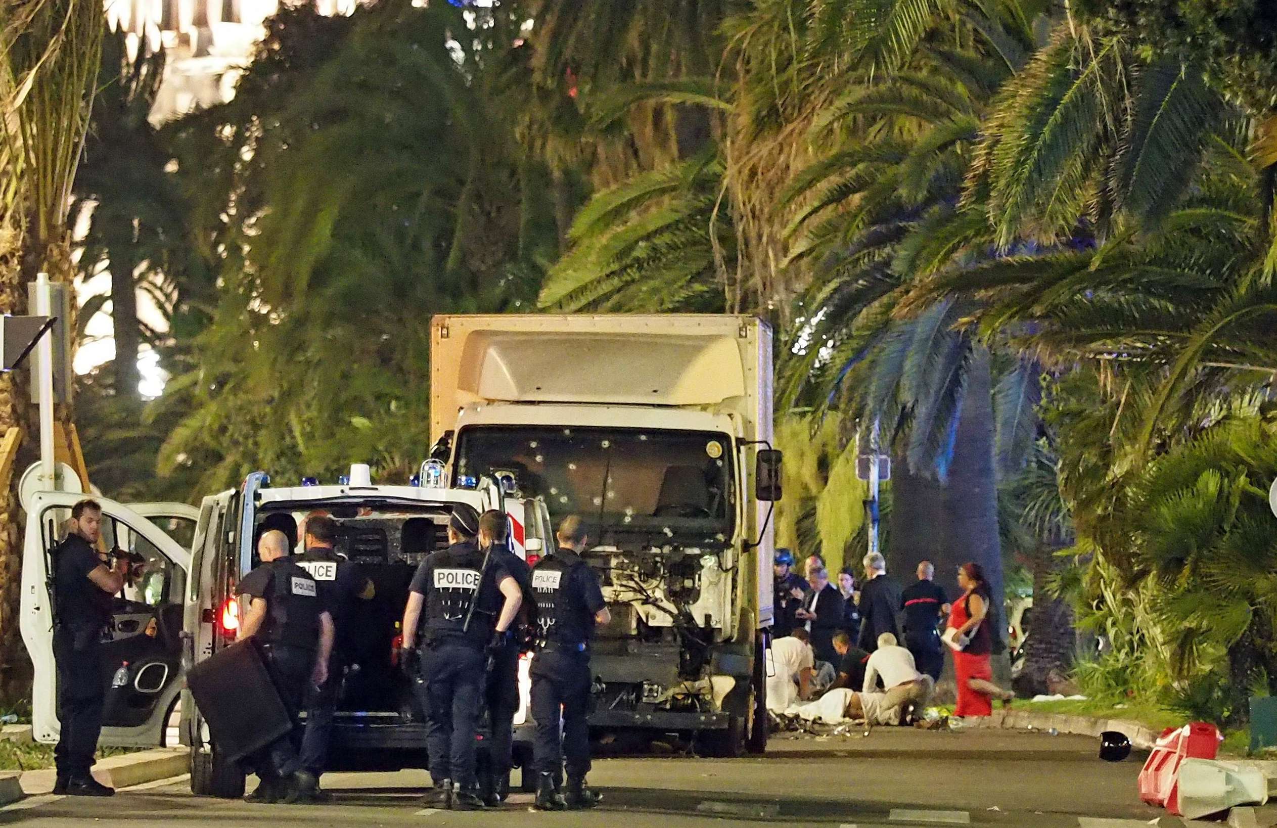 Police stand by as medical personnel attend a person on the ground, right, in the early hours of Friday, July 14, 2016, on the Promenade des Anglais in Nice, southern France, next to the lorry that had been driven into crowds of revellers late on Thursday. Photo: AP