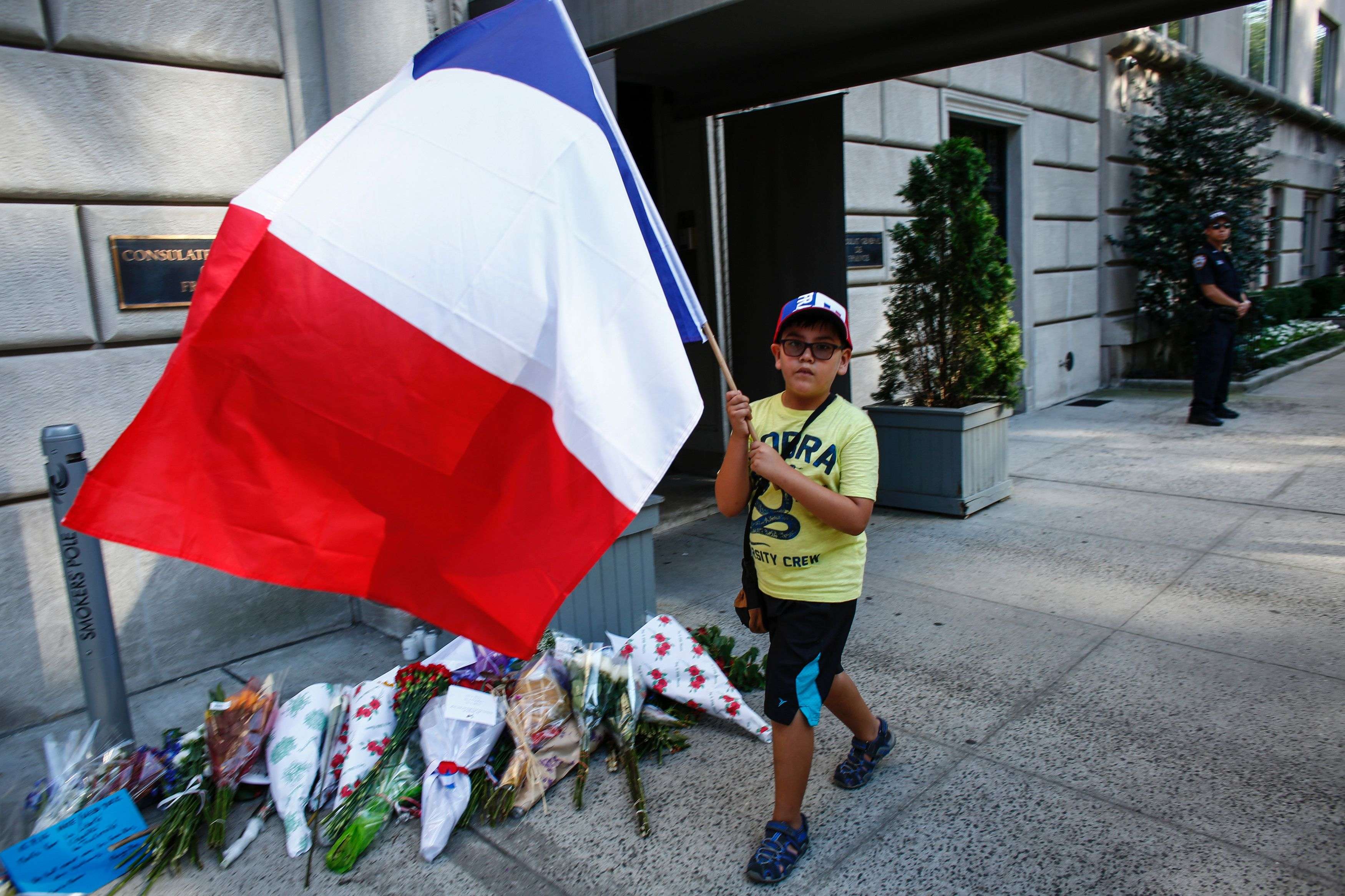 A boy carriers a French flag outside the French Consulate in New York. Photo: AFP