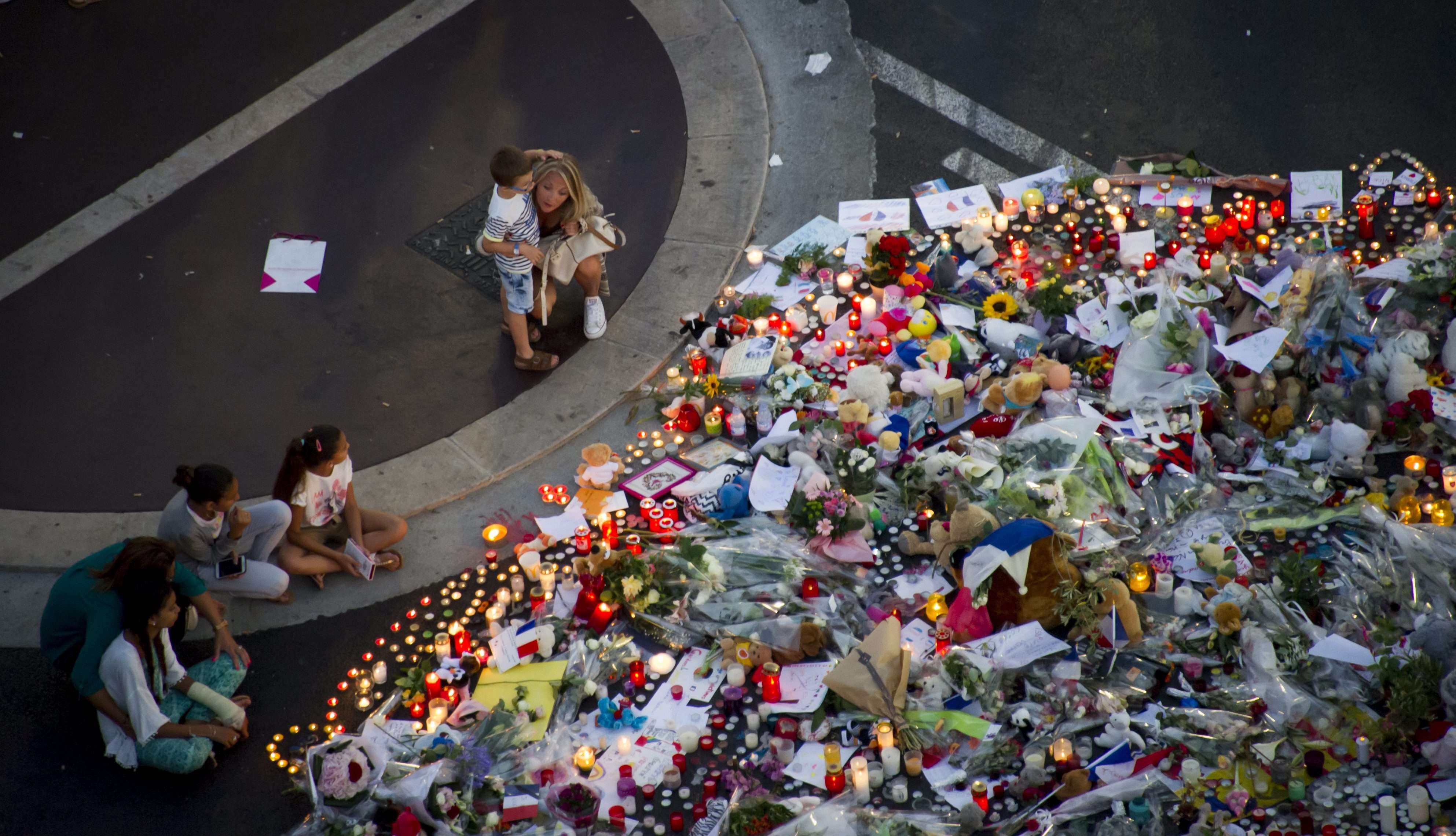 People gather at a makeshift memorial of flowers and candles on the 'Promenade des Anglais', scene of the Bastille Day truck attack tat killed 84 people. Photo: EPA