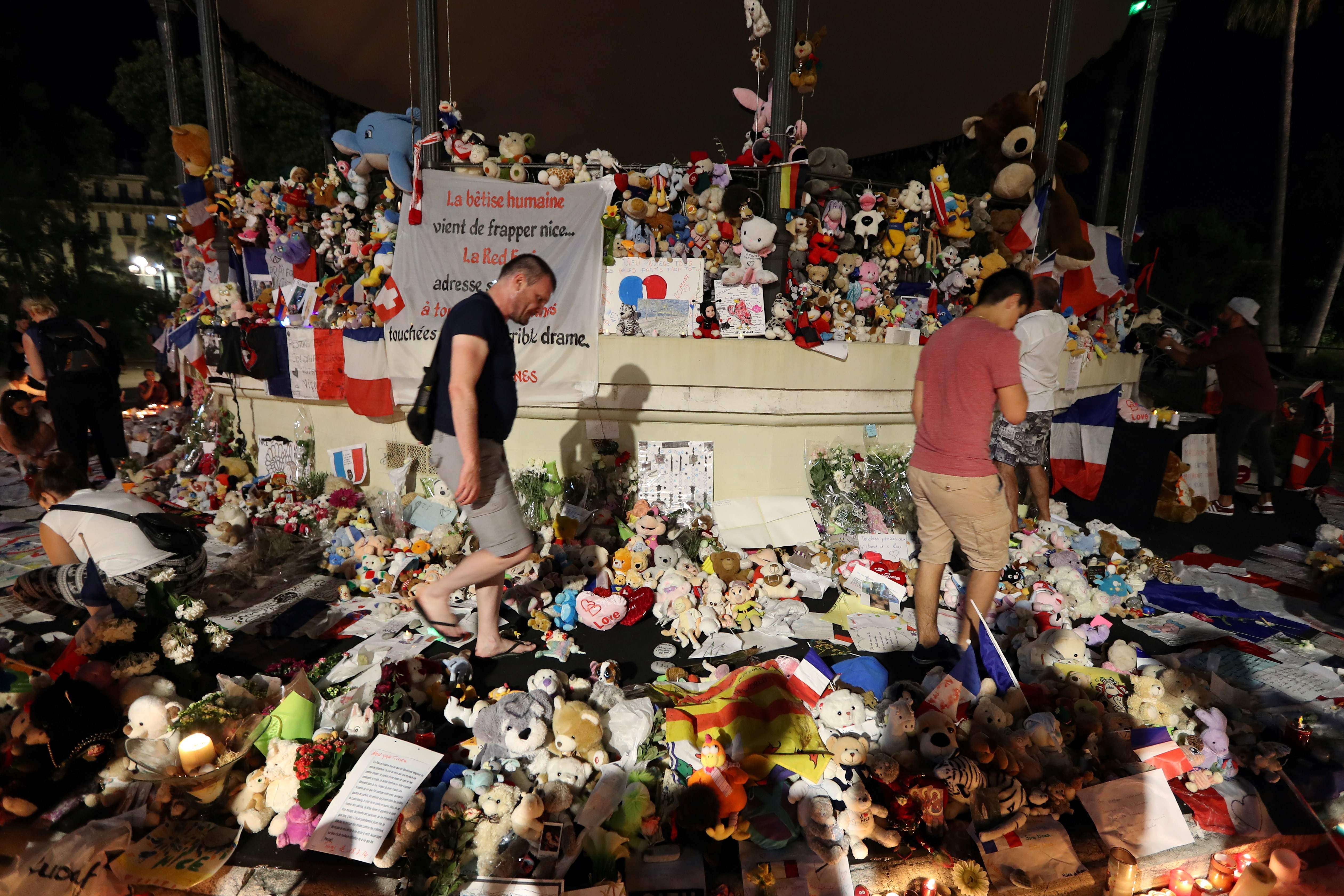 People walk through a makeshift memorial to victims of the Bastille Day truck attack in Nice on Monday. Photo: AFP