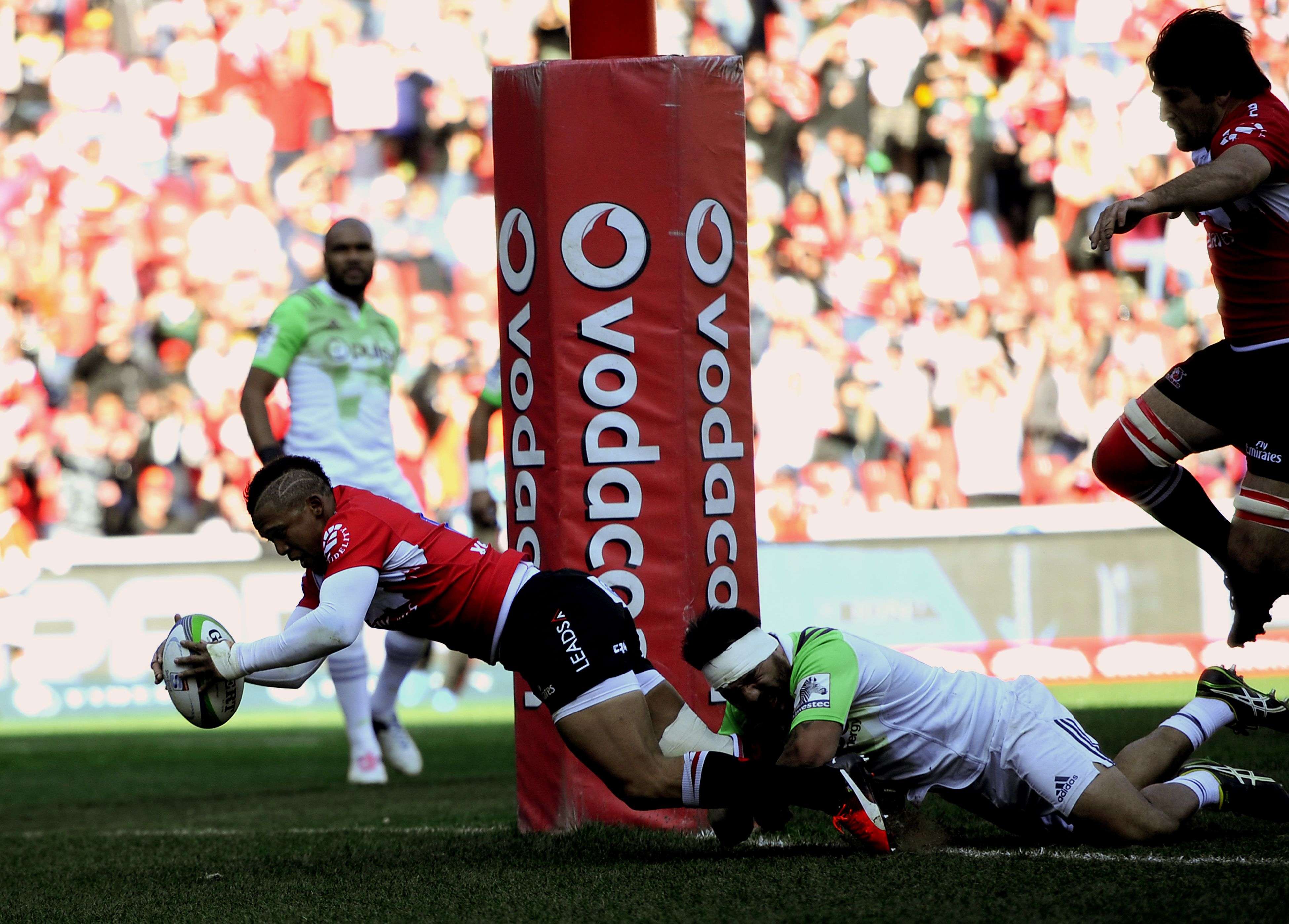 Golden Lions fly-half Elton Jantjies scores a try while being tackled by Ash Dixon of the Highlanders during their Super Rugby semi-final at Ellis Park in Johannesburg on Saturday. Photo: AFP