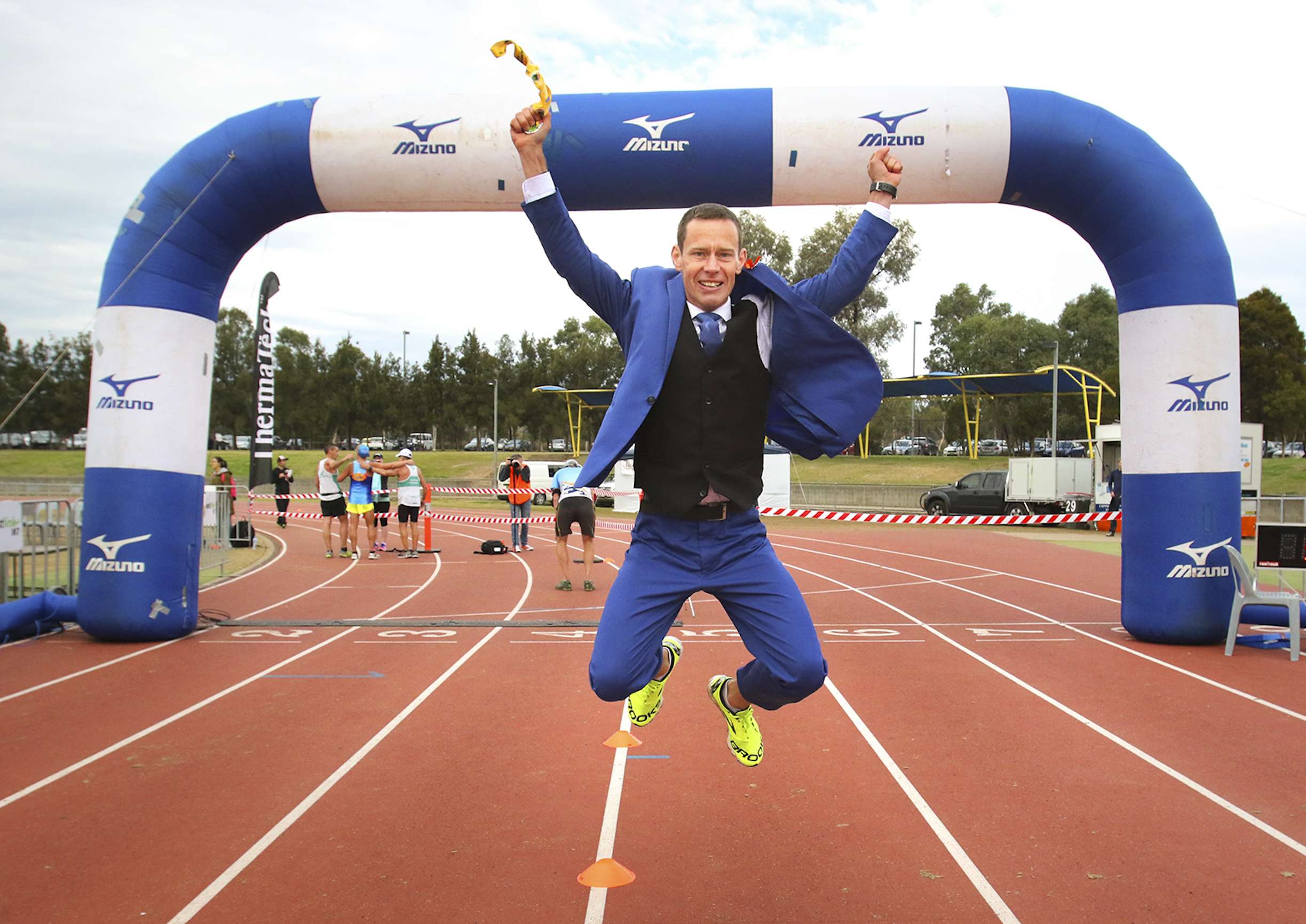 Mike Tozer celebrates running a half-marathon in a three-piece suit in record time. Photo: Drew Grigg/Yet Another Idea