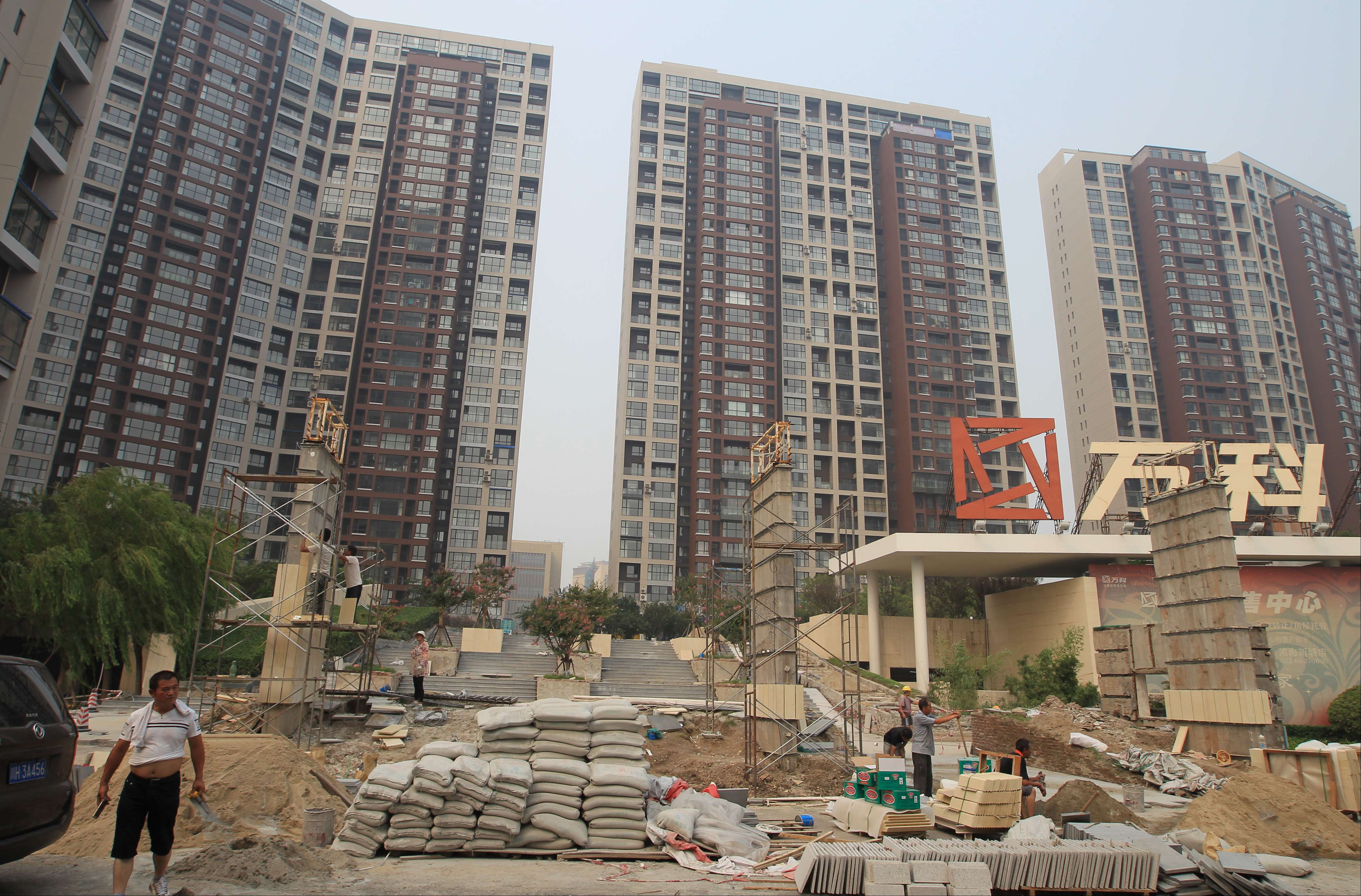 The entrance to a residential area is under renovation in Tianjin a year after the blasts. Many windows in these buildings were damaged in last year's explosions. Photo: Simon Song