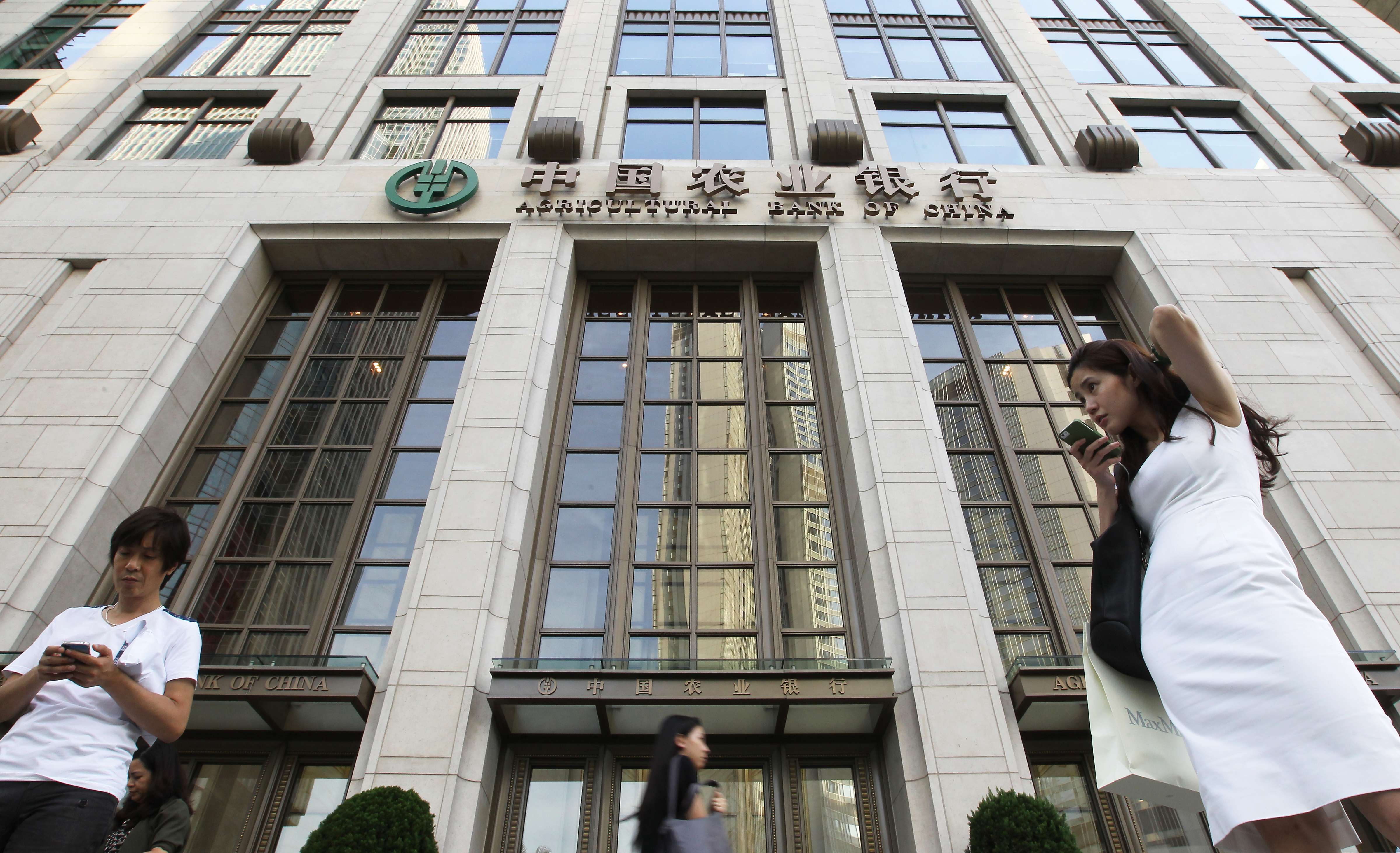 People walk pass Agricultural Bank of China Tower in Central, Hong Kong. Three of the country’s five largest banks have already reported first-half profit growth of between half a percentage point and 1.3 per cent, all weighed down by dwindling net interest income. Photo: Edward Wong