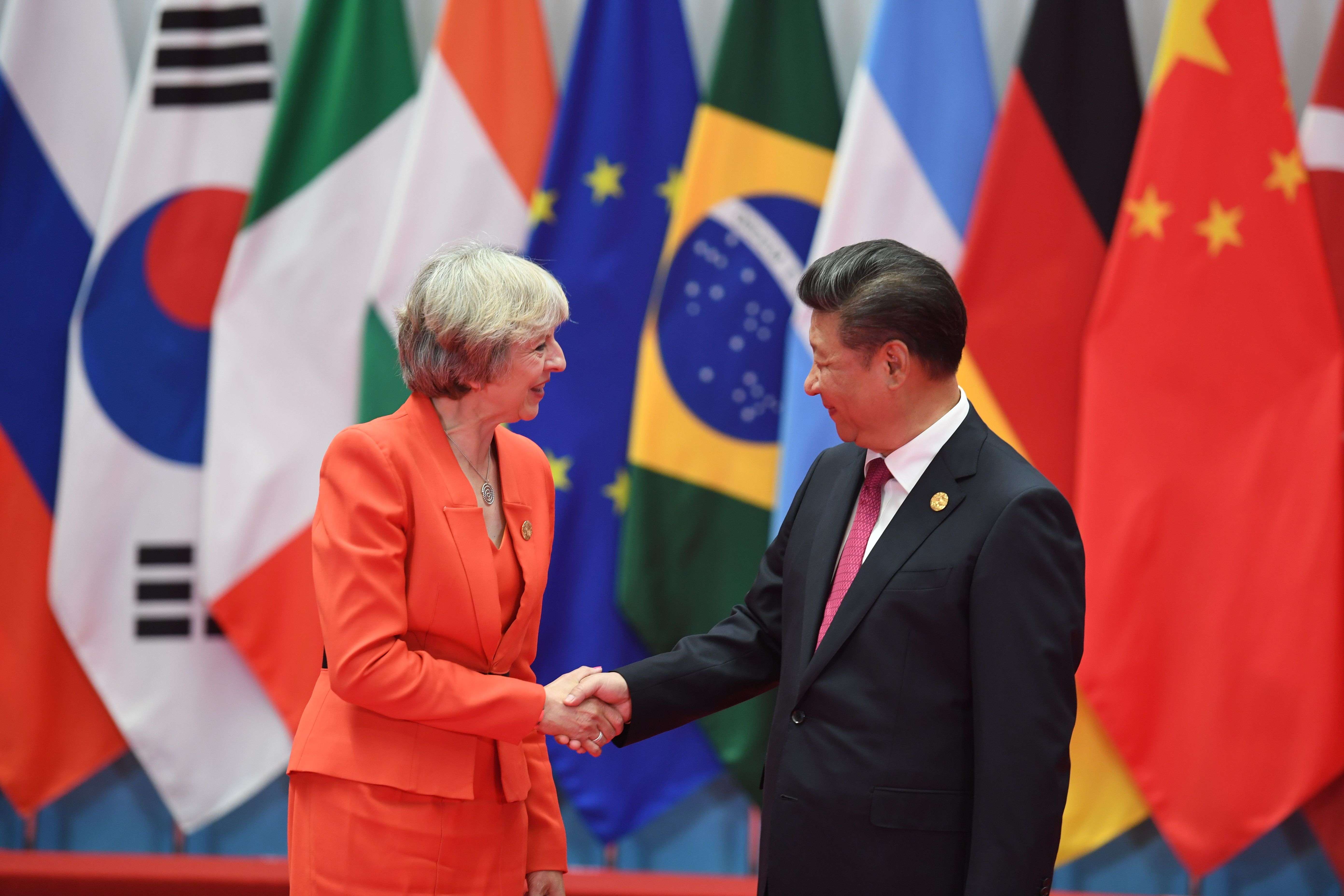 British Prime Minister Theresa May shakes hands with President Xi Jinping on Sunday. Photo: AFP