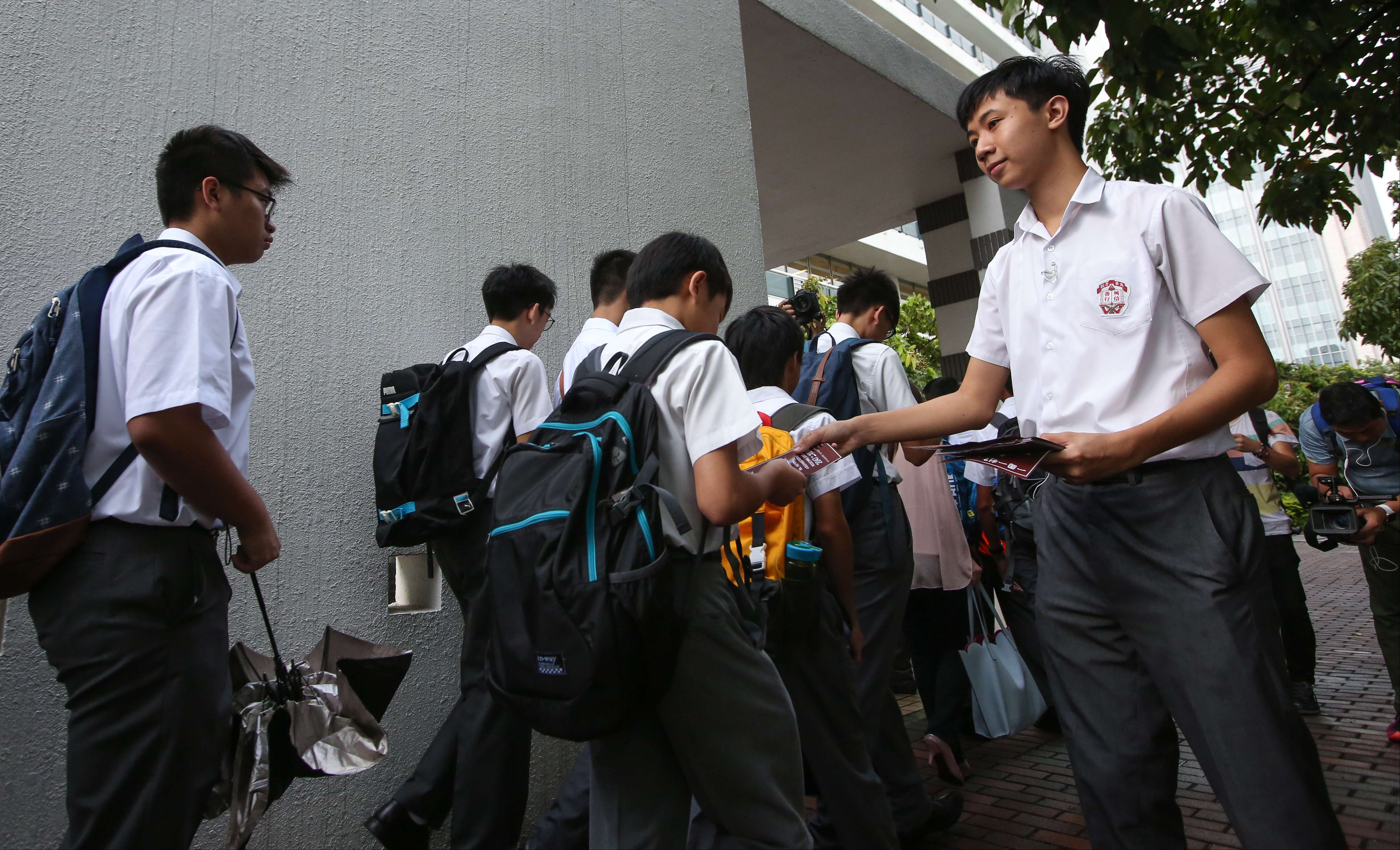 A student from Ying Wa College hands out leaflets on Hong Kong independence on the first day of school. Photo: Edward Wong