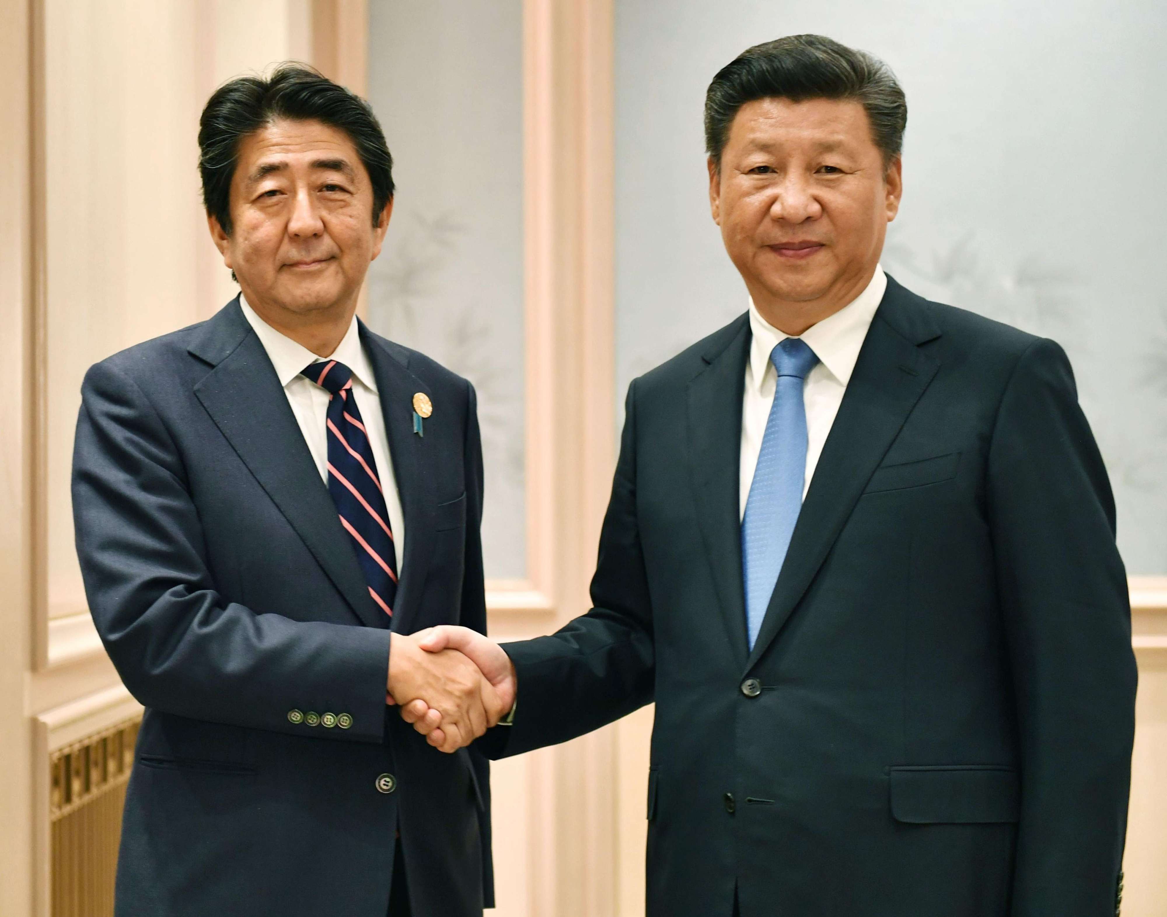 President Xi Jinping, right, and Japanese Prime Minister Shinzo Abe shake hands before their bilateral meeting on the sideline of the G-20 Summit on Monday. Photo: Kyodo