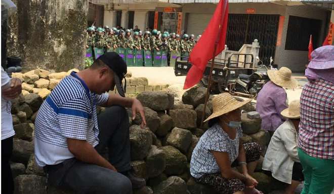 Villagers rest under the watch of security officers in Wukan in Guangdong province. Photo: SCMP Pictures