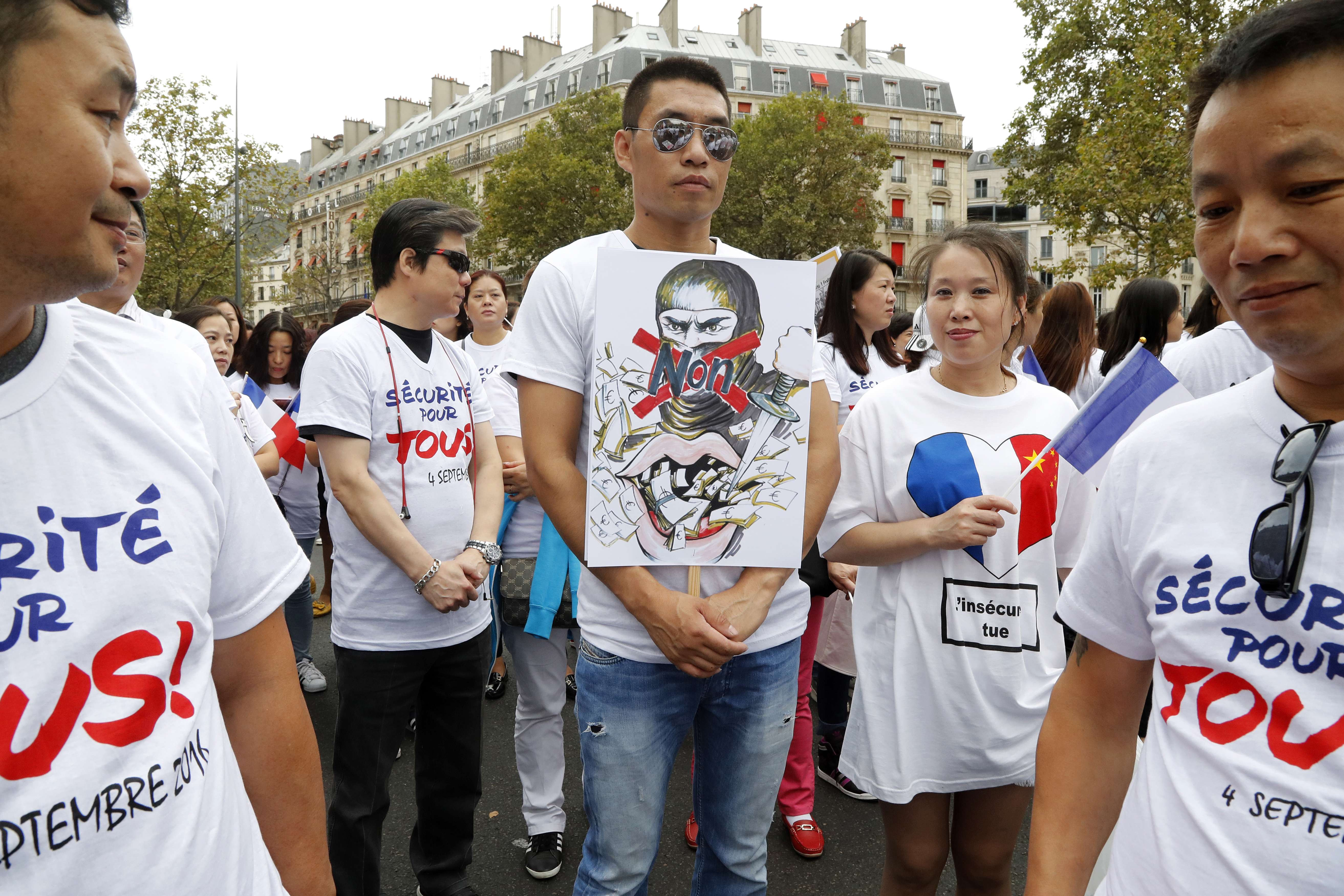 A members of the Chinese commmunity in Paris holds a placard during a demonstration on September 4, 2016 in Paris, following the death of Zhang Chaolin and also calling for greater security measures. Photo: AFP