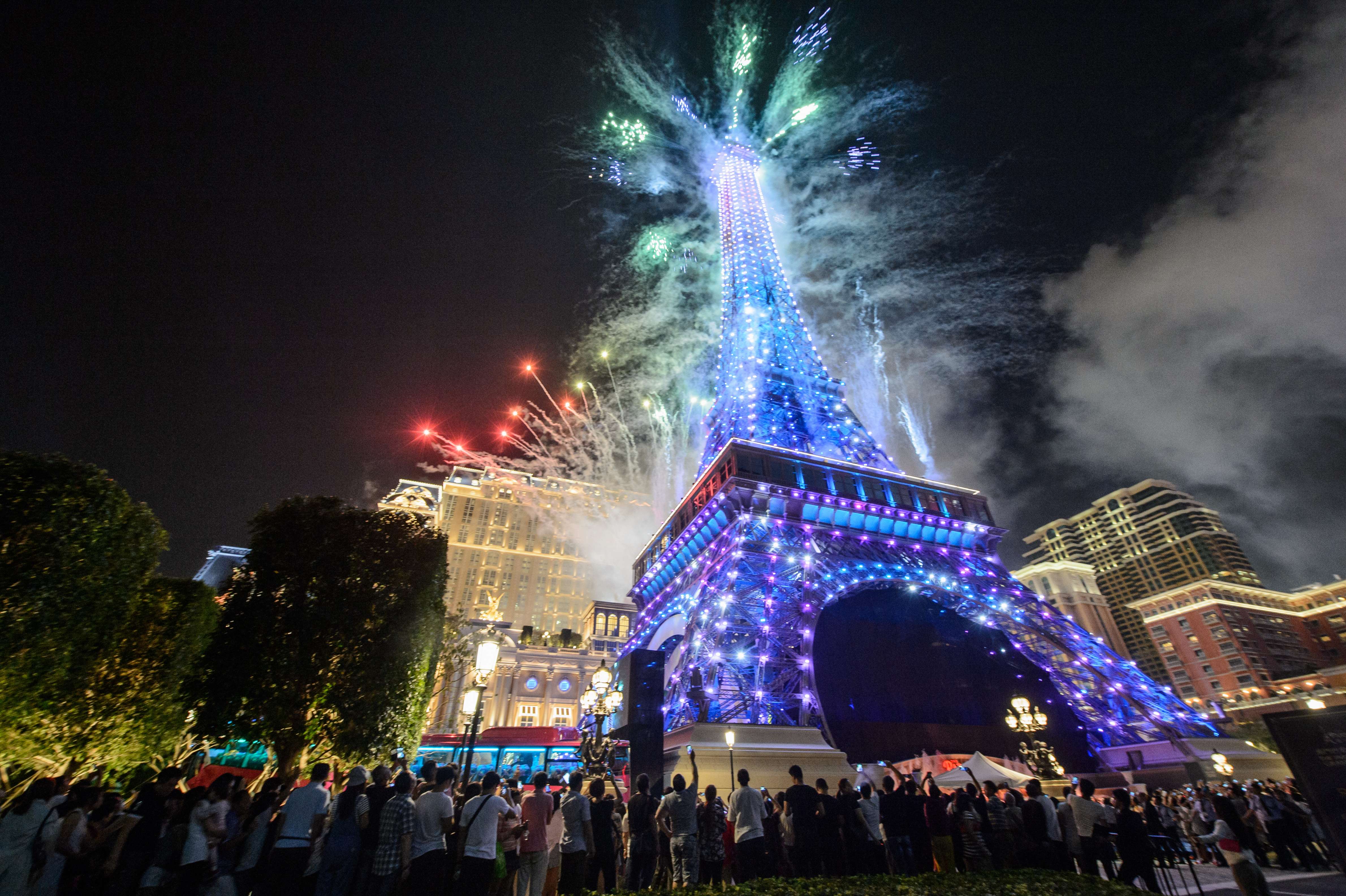 People gather to watch fireworks exploding from a replica of the Eiffel Tower after the opening of the Sands new mega resort The Parisian in Macau, on September 13, 2016. Photo: AFP