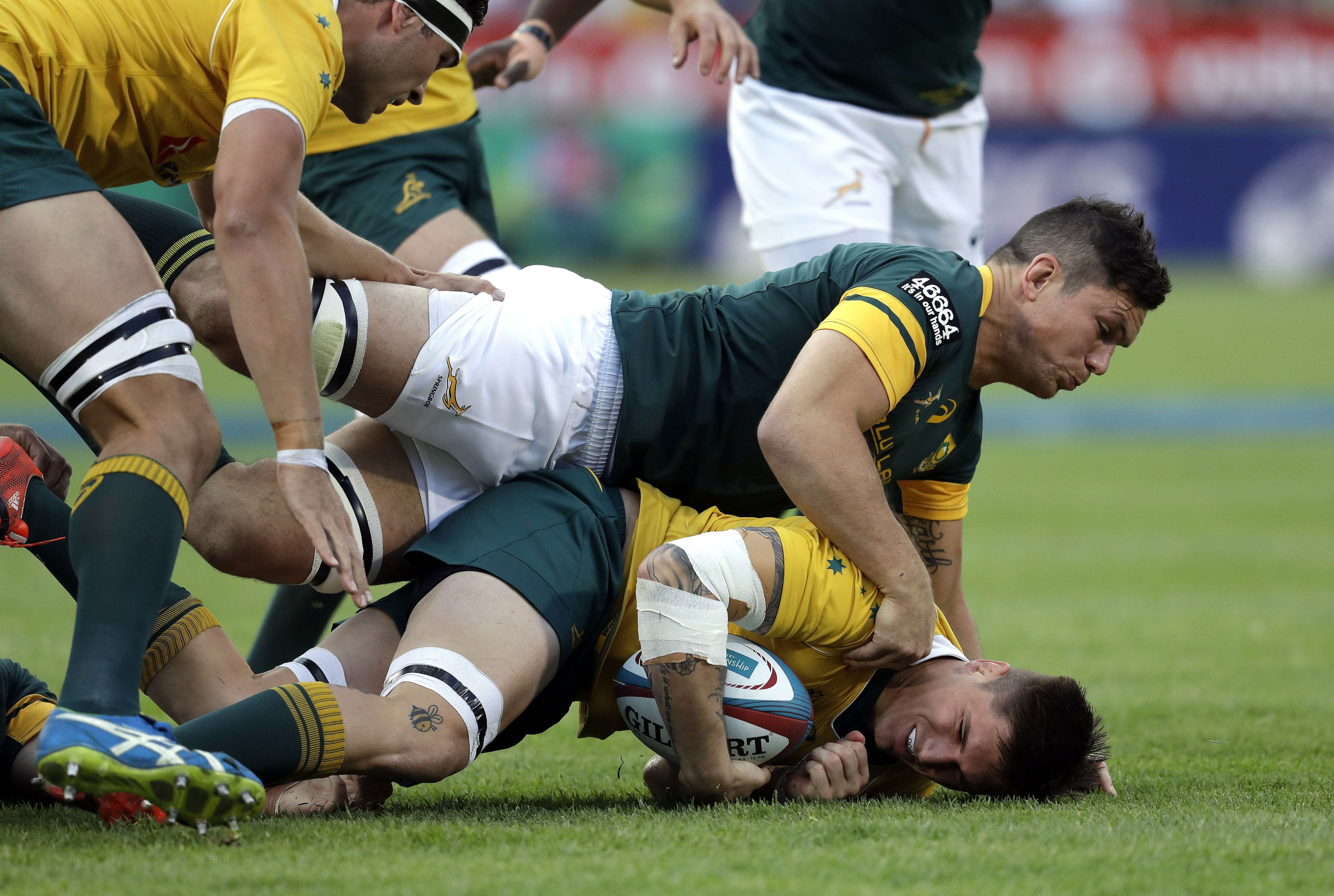 Australia’s Sean McMahon is tackled by South Africa’s Francois Louw. Photo: AP