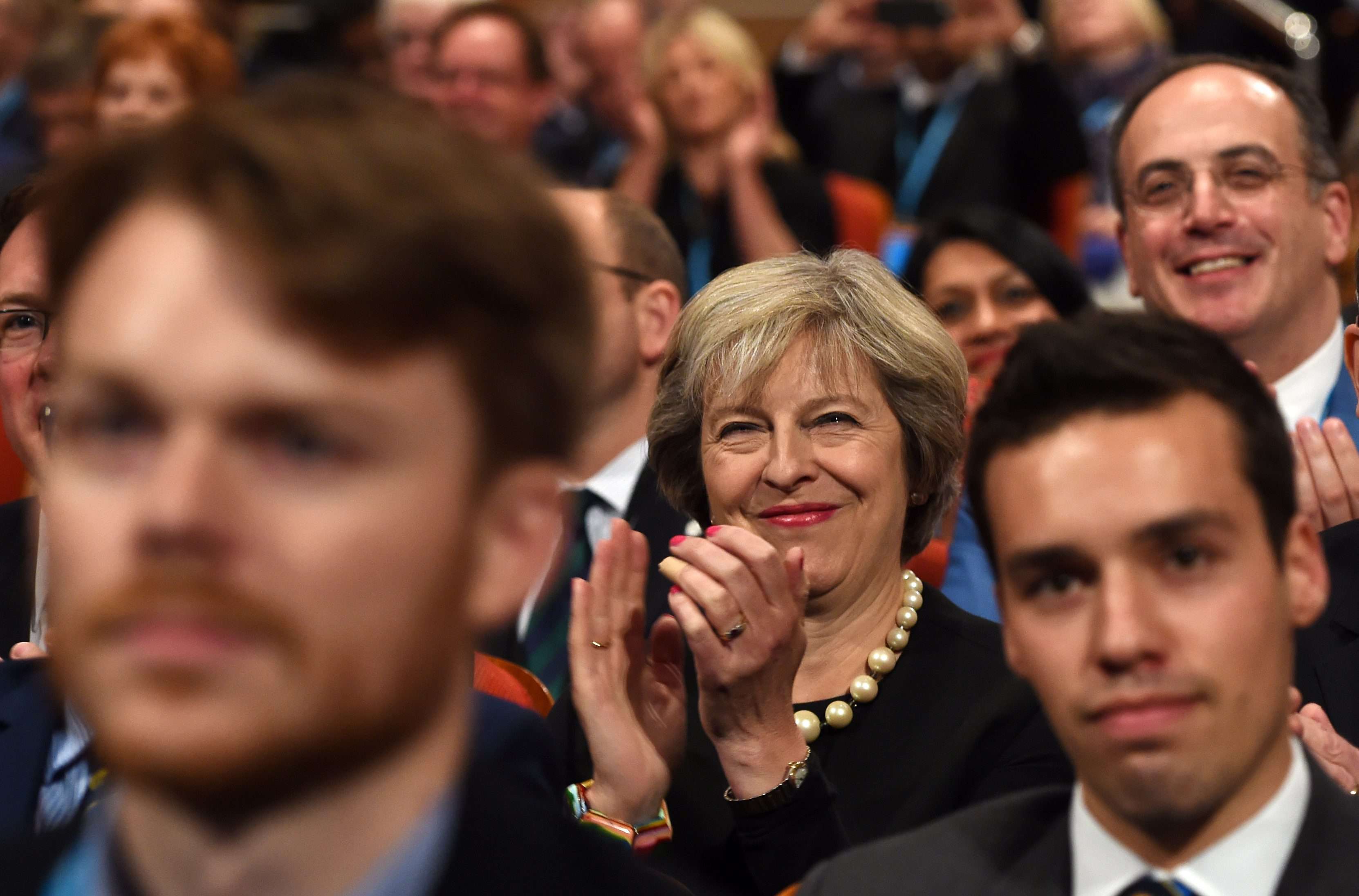 British Prime Minister Theresa May smiles as she listens to delegates during the Conservative Party conference in Birmingham. Photo: EPA