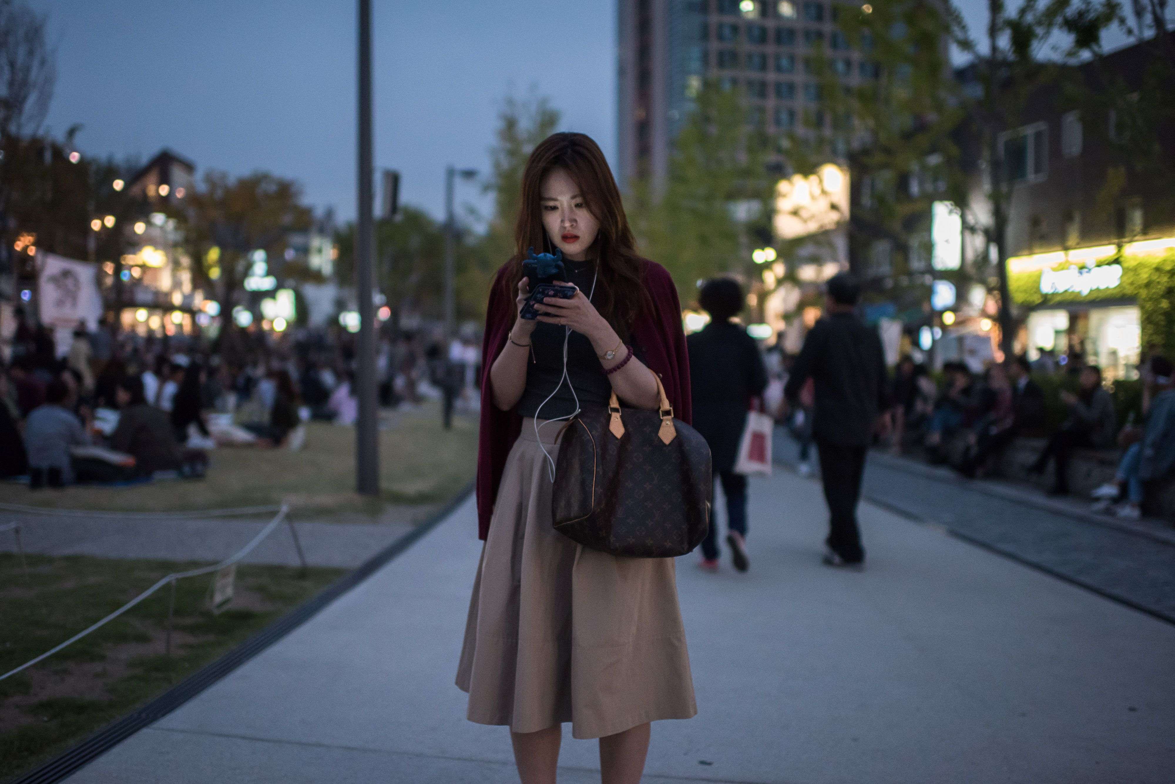 A woman in downtown Seoul uses her mobile phone. We live in an age of public information sharing, and do not need to suffer in silence private acts of shaming. Photo: AFP