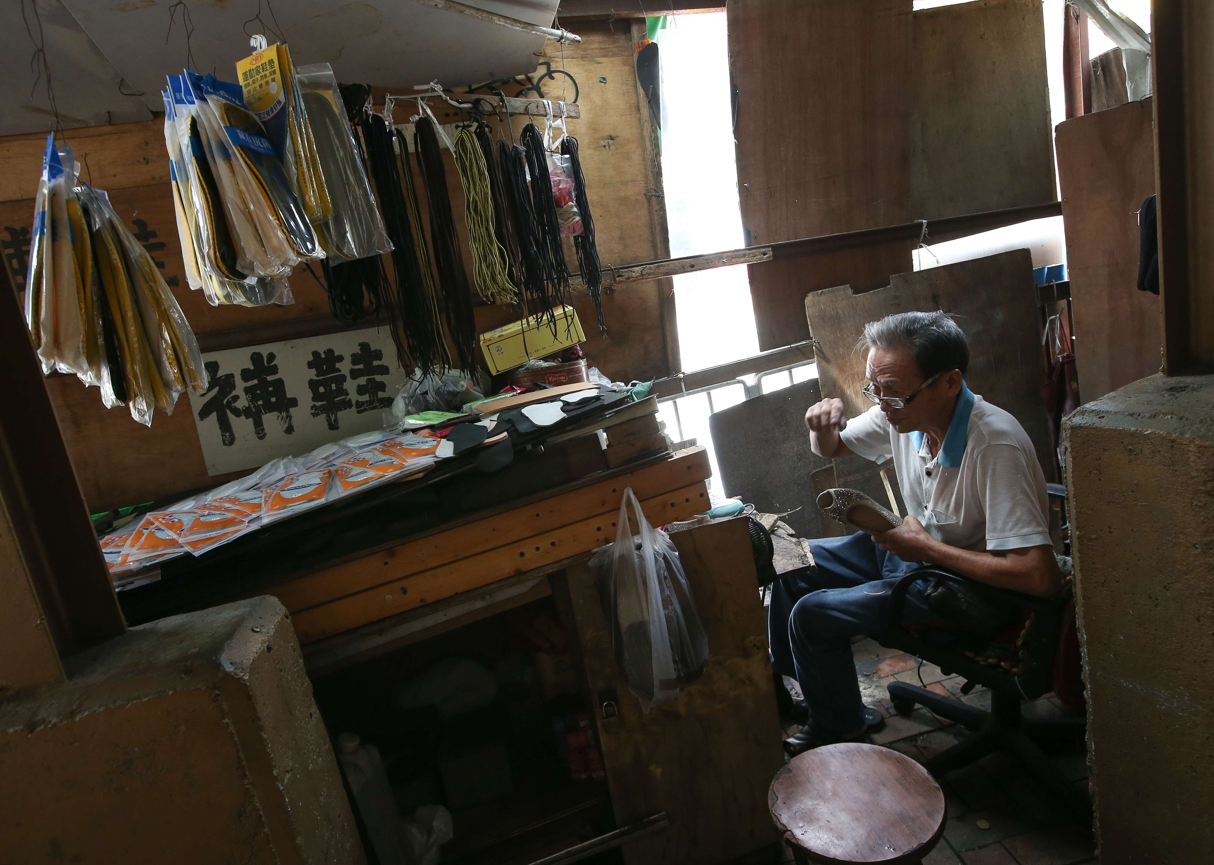 Shoemaker Lau Tai-kuen plying his trade in Kwun Tong on Thursday. Photo: David Wong