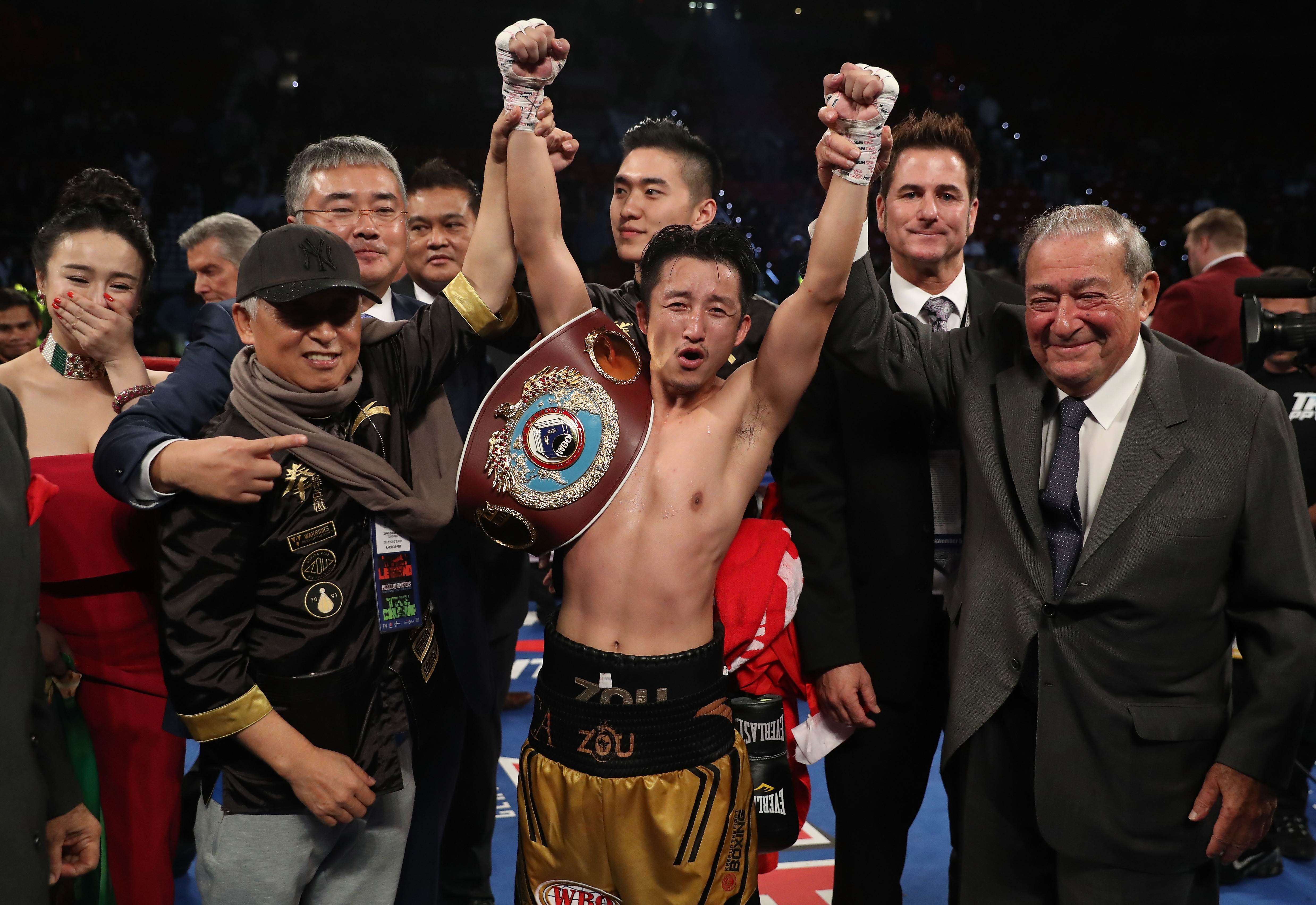Zou Shiming of China poses with his wife, Yingying Ran, Top Rank Founder and CEO Bob Arum, and his team after his unanimous-decision victory over Prasitsak Phaprom of Thailand during their WBO flyweight championship fight at the Thomas & Mack Centre in Las Vegas. Photo: AFP
