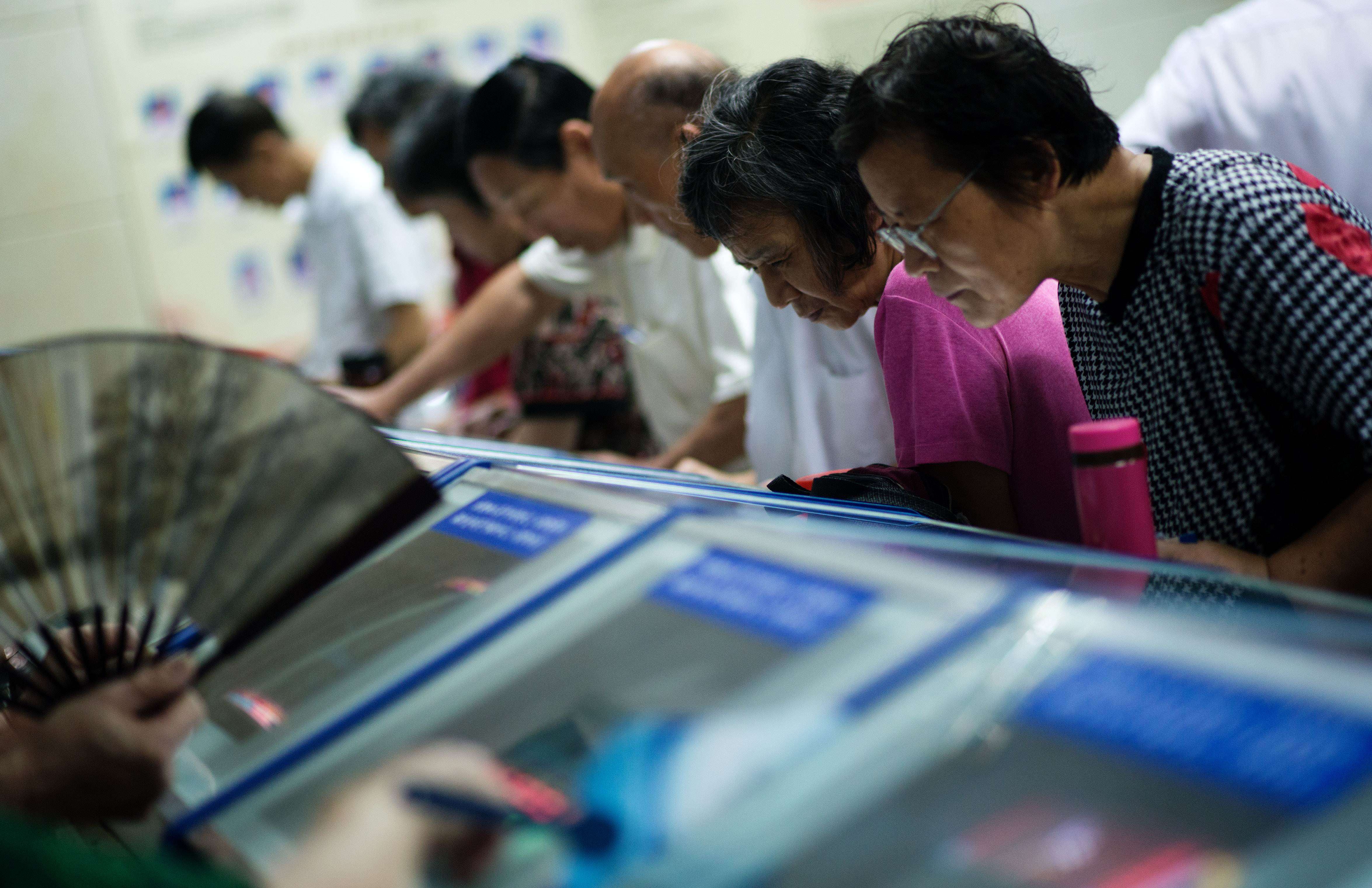 Investors look at stock prices at a securities exchange in Shanghai. Photo: AFP