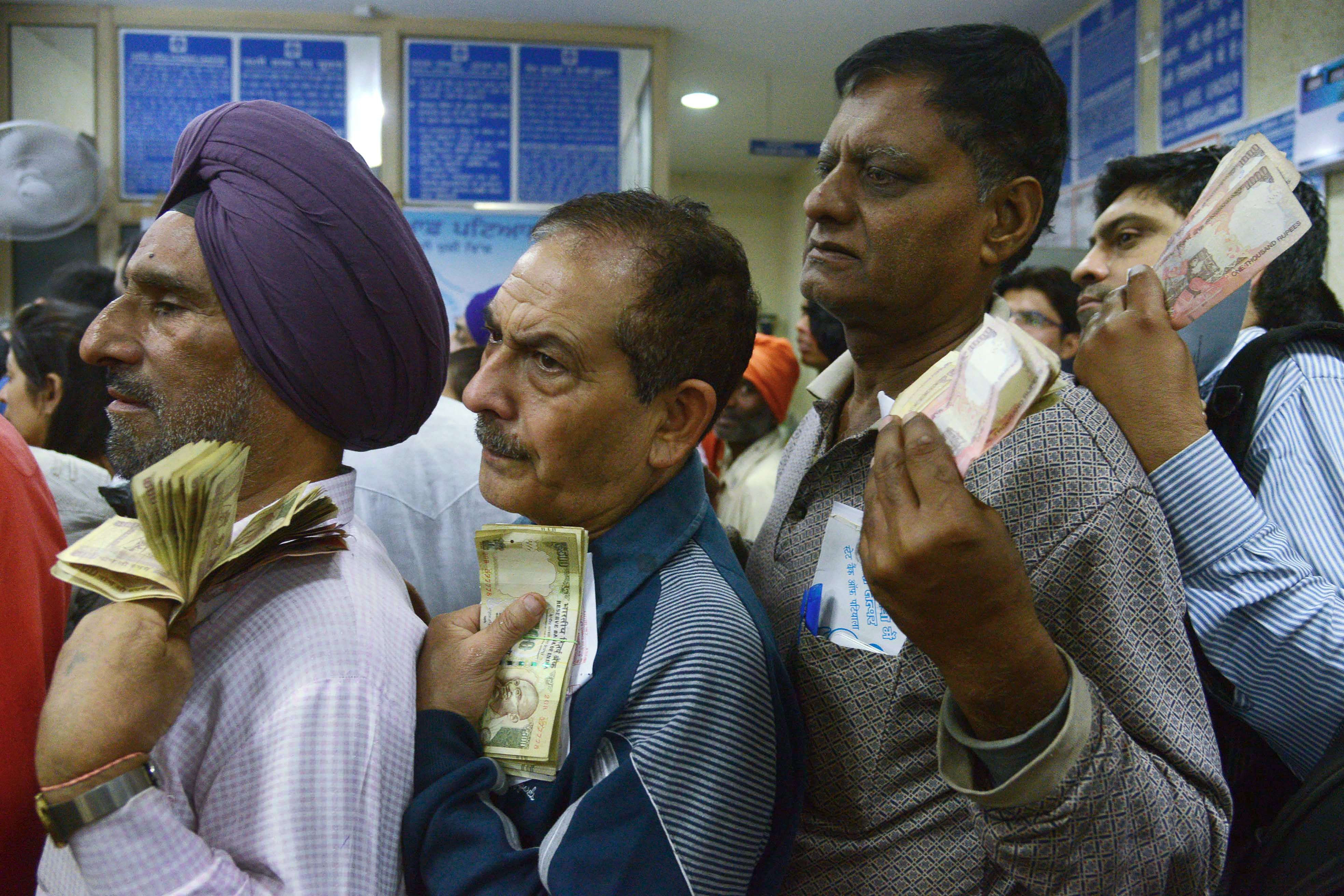 Indian bank customers queue up to exchange the newly worthless banknotes. Photo: AFP