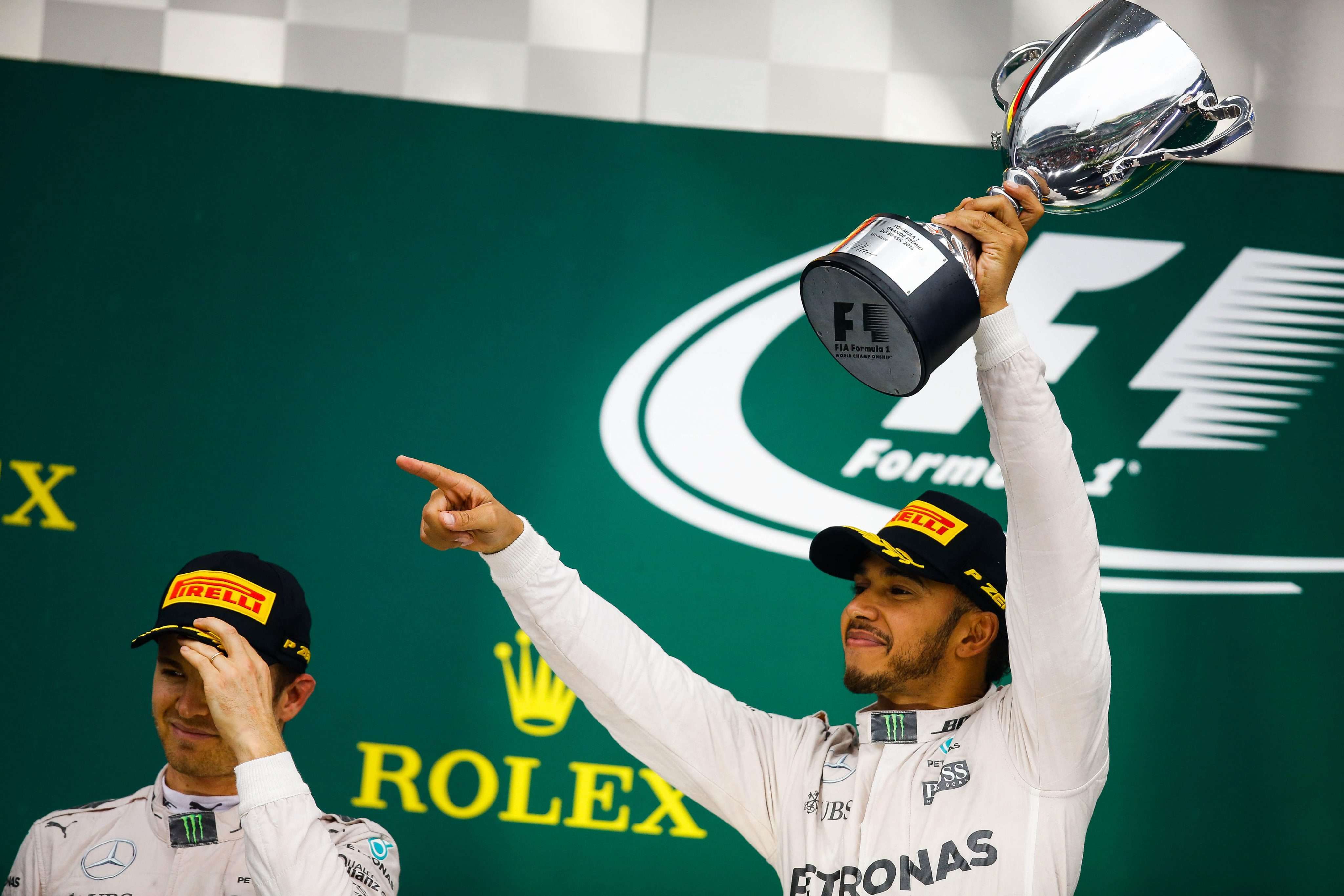 British driver Lewis Hamilton and German Nico Rosberg, both of Mercedes, celebrate on the podium after finishing in first and second place respectively at the Brazilian Grand Prix. Photo: EPA