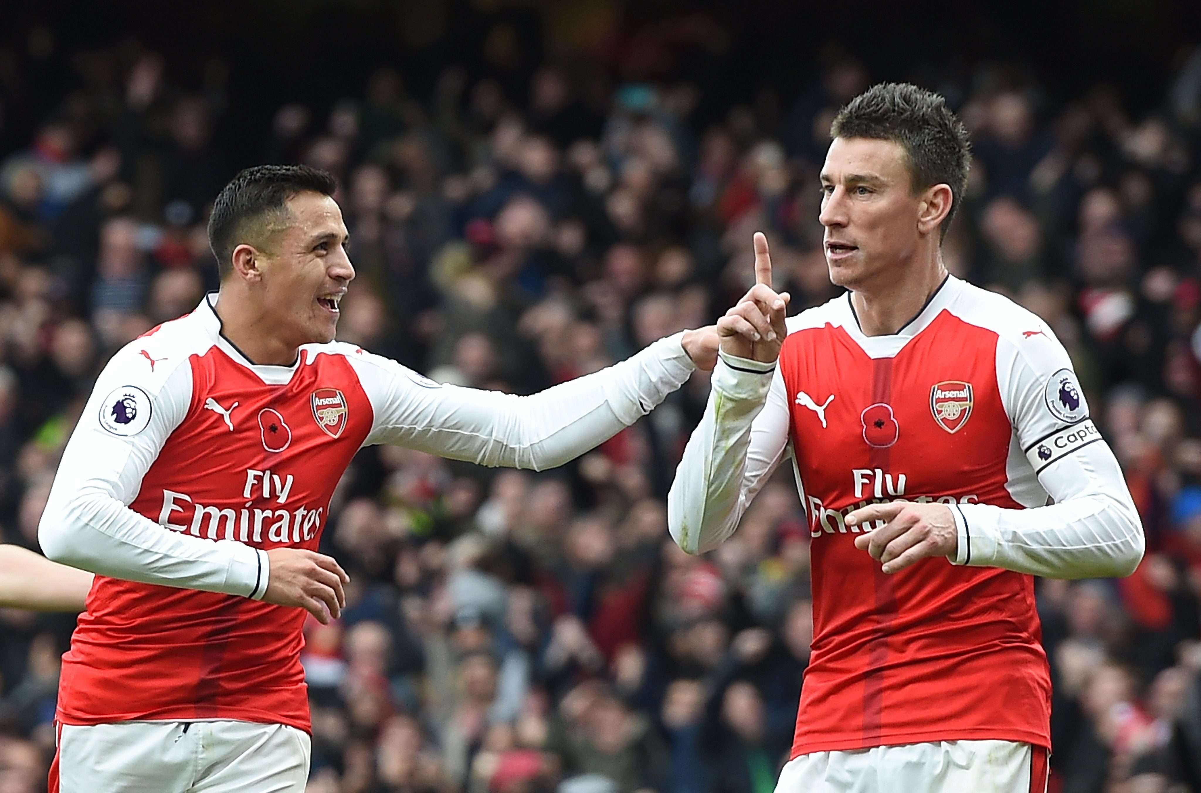 Arsenal's Laurent Koscielny (right) celebrates with Alexis Sanchez after Tottenham's Kevin Wimmer scored an own goal during their match on November 6. Photo: EPA