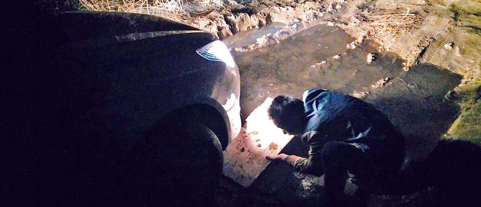 The stranded driver uses a conventional road map after his phone’s GPS route left his car stuck in a muddy ditch. Photo: SCMP Pictures