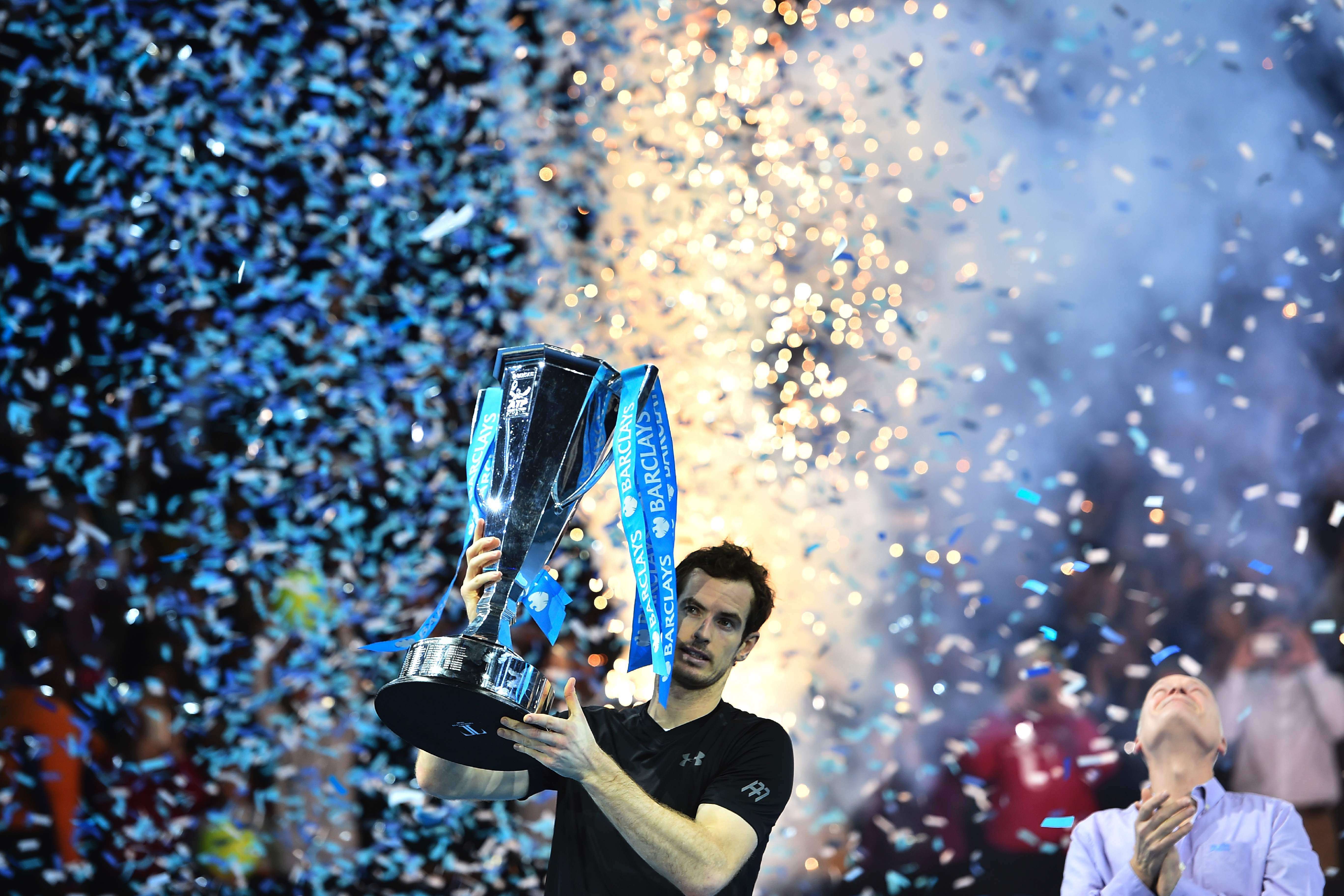 Britain's Andy Murray celebrate with the trophy after winning the men's singles final against Serbia's Novak Djokovic on the eighth and final day of the ATP World Tour Finals tennis tournament in London on November 20, 2016. / AFP PHOTO / Glyn KIRK