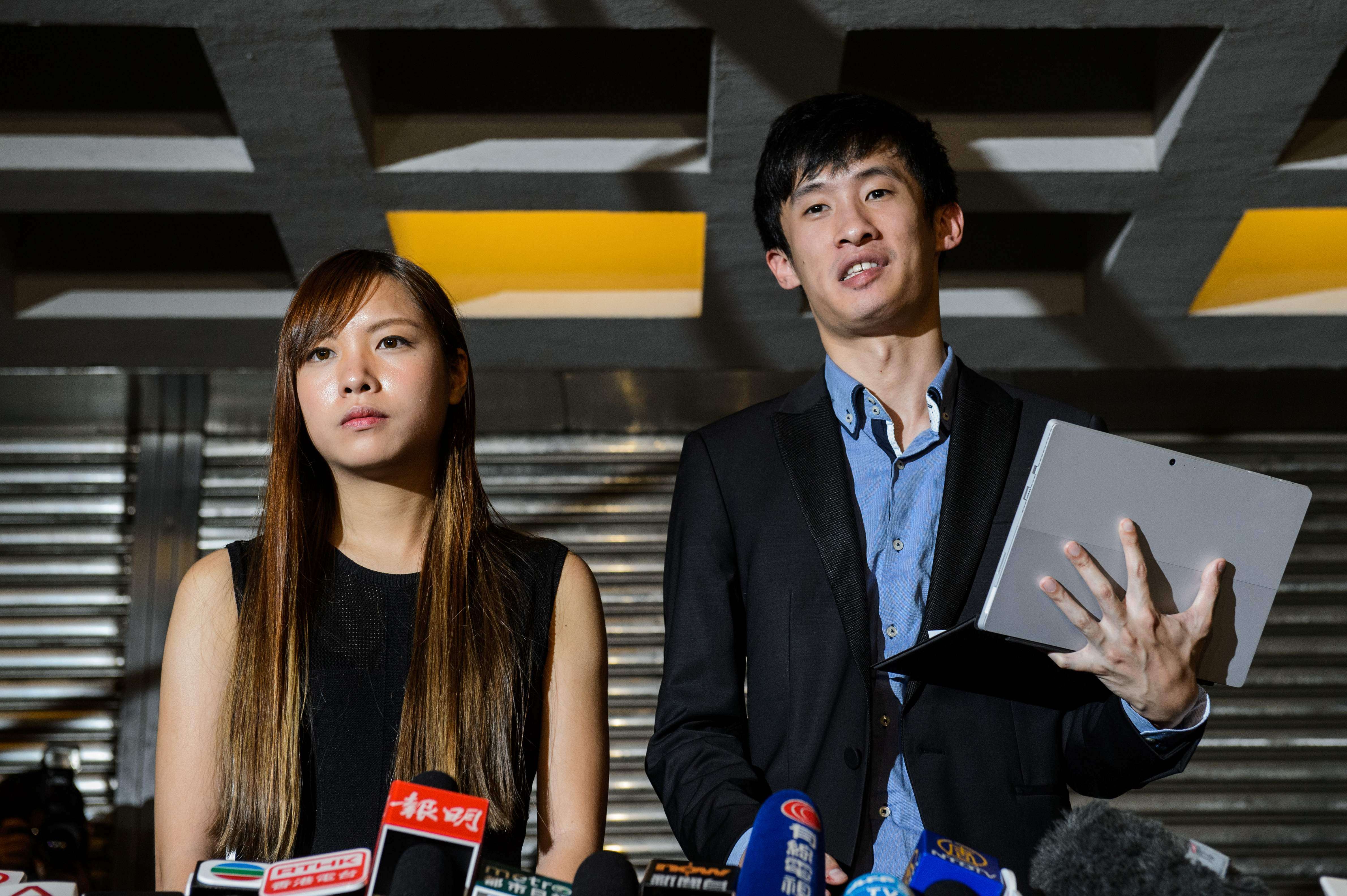 Yau Wai-ching and Sixtus Baggio Leung speak to reporters outside the High Court in Hong Kong on November 15, after the court ruled to disqualify the two lawmakers-elect. Photo: AFP