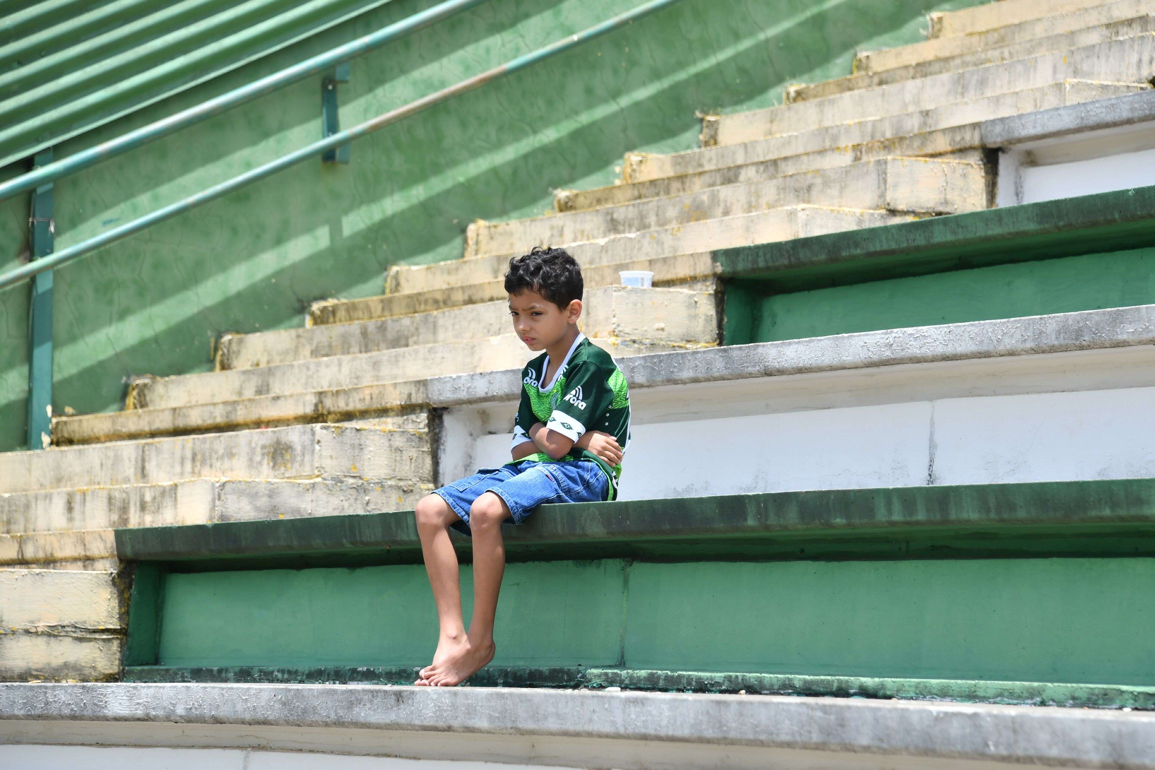 A boy sits alone on the stands during a tribute to the players and officials of Brazilian club Chapecoense Real who were killed in a plane accident in the Colombian mountains. Photo: AFP