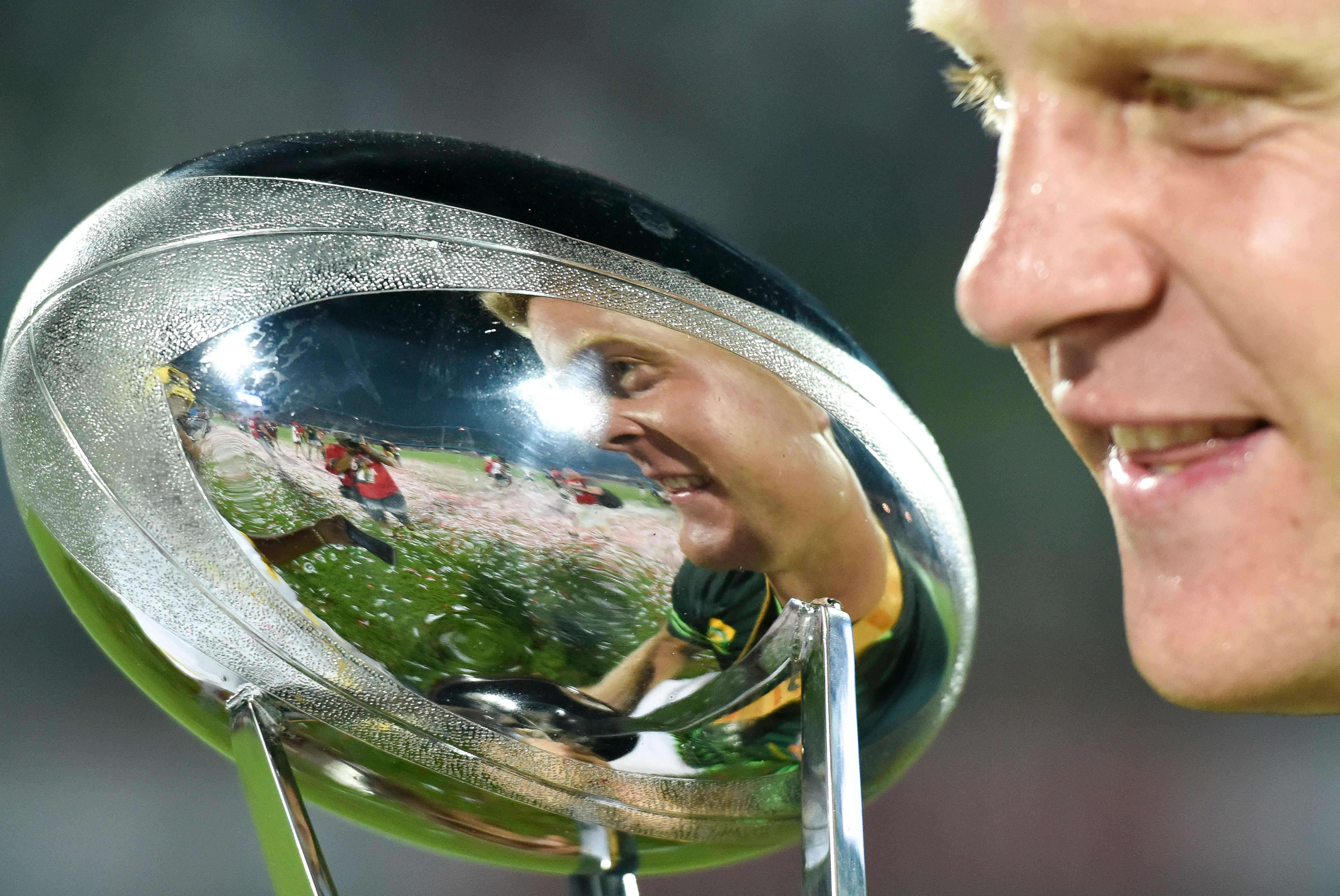 South Africa’s Dylan Sage admires the trophy after beating Fiji. Photo: AFP