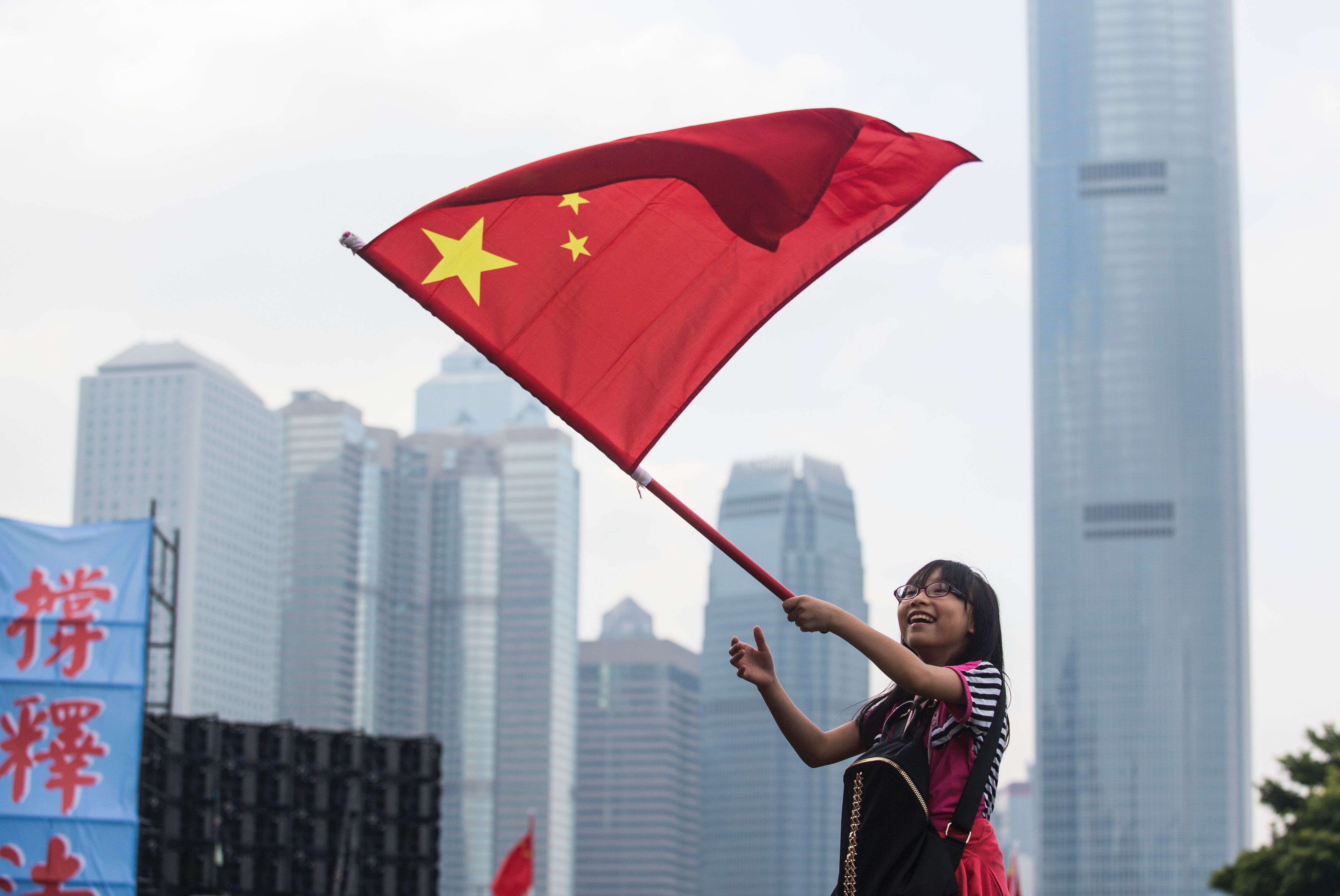 A young woman waves the national flag at a rally last month in support of the NPC’s interpretation of the Basic Law. Hong Kong people must fight the independence movement openly, with flags waving. Photo: AFP
