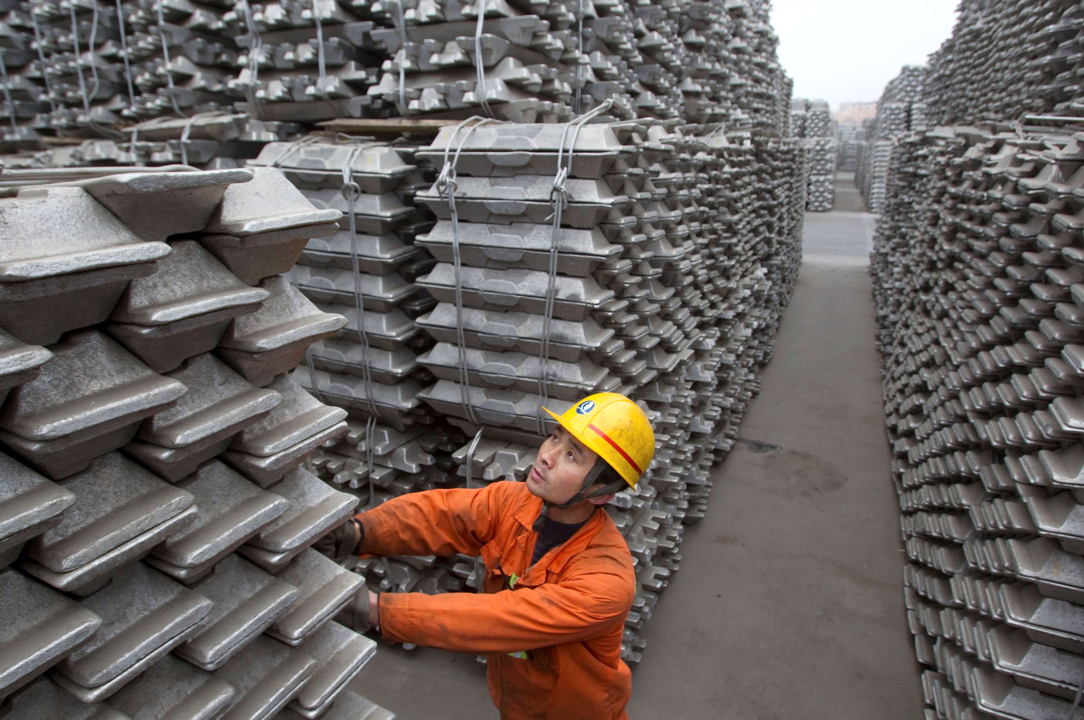 An employee checks aluminium ingots for export. Photo: Reuters