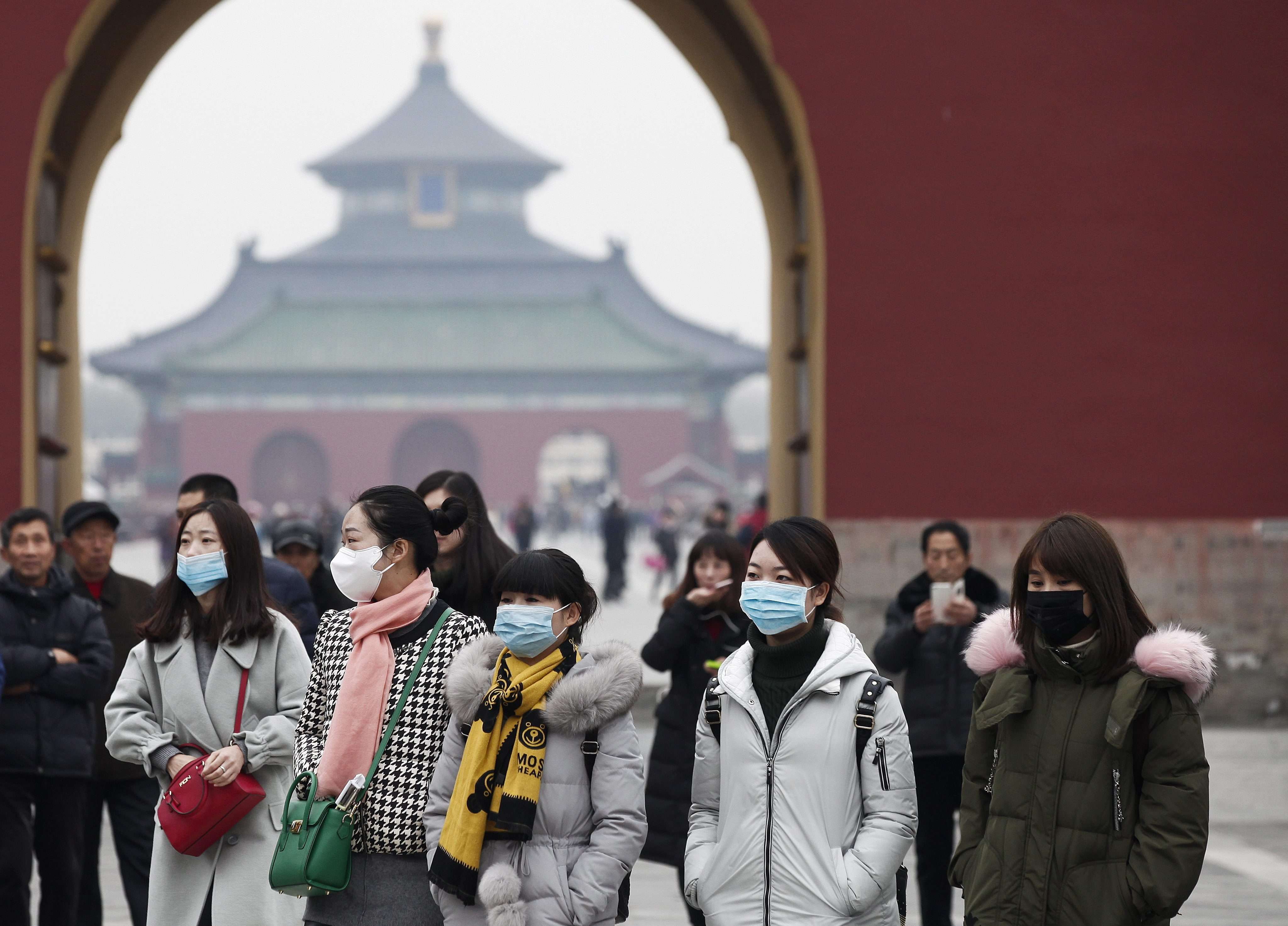 Tourists wear protective masks while going around Tiantan Park in Beijing. The active Sino-US cooperation on climate under Barack Obama will end with Trump, analysts say. Photo: EPA