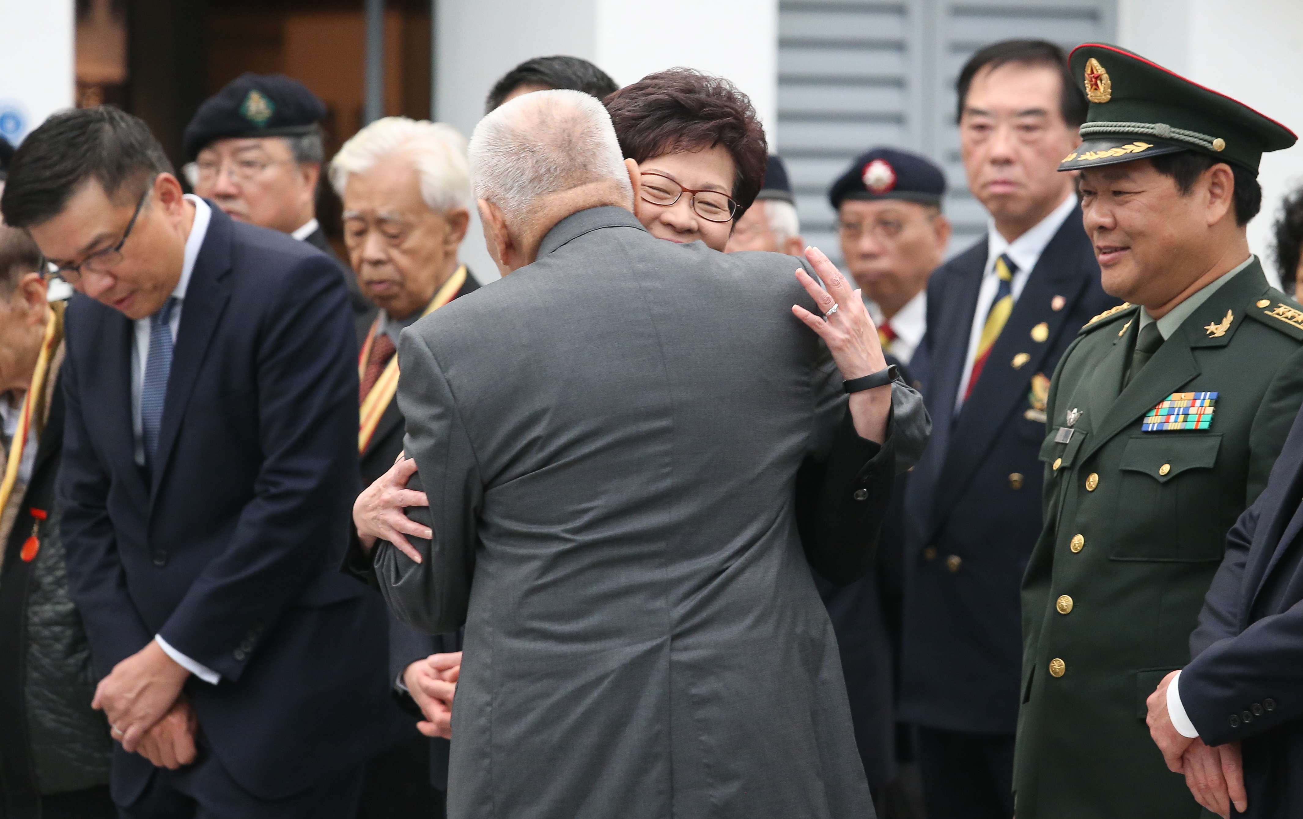 Former chief executive Tung Chee-hwa gives Chief Secretary Carrie Lam a hug during the official ceremony in Shau Kei Wan to commemorate the Nanking massacre. Photo: K. Y. Cheng