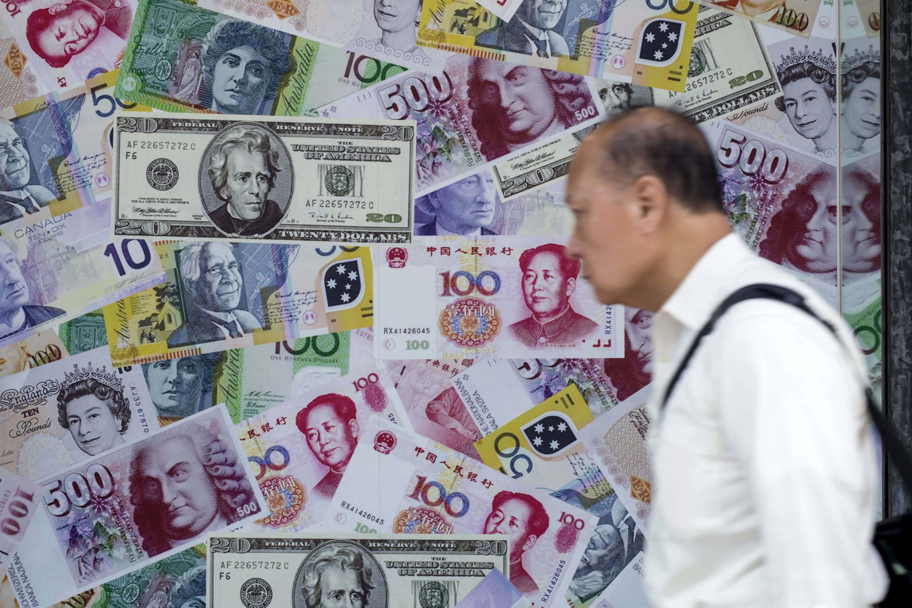 A man walks past an advertisement promoting China's renminbi (RMB) or yuan, U.S. dollar and Euro exchange services at a foreign exchange store in Hong Kong. China’s government bonds tumbled by their daily allowable limits on Thursday after the US Fed foreshadowed three possible interest rate increases in 2017, one more than consensus. Photo: Reuters