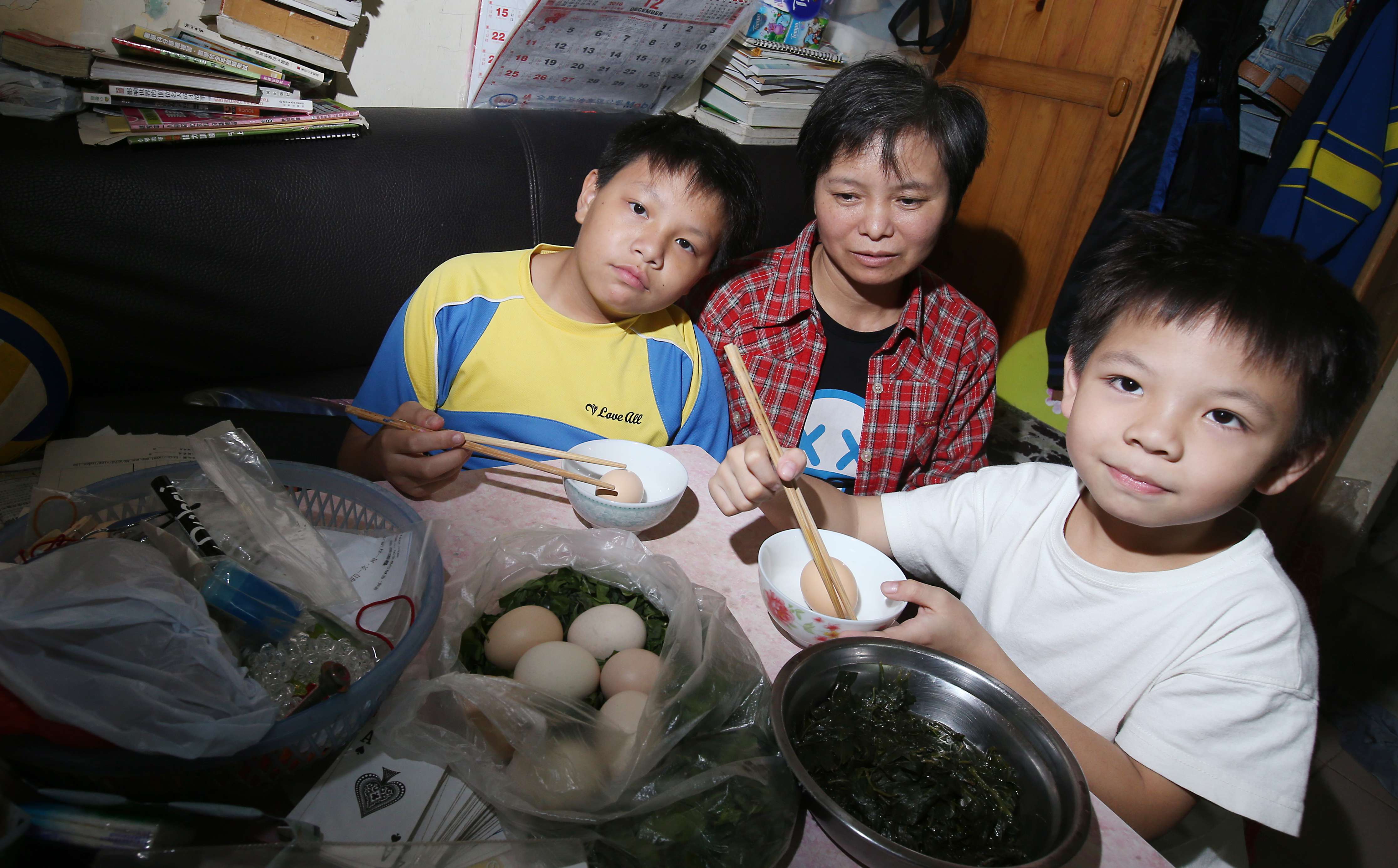 Li Ching-wan, 12; his mother Li Yan-ling; and his brother Tang Chung-kai, 9, at home in Sham Shui Po. Photo: David Wong