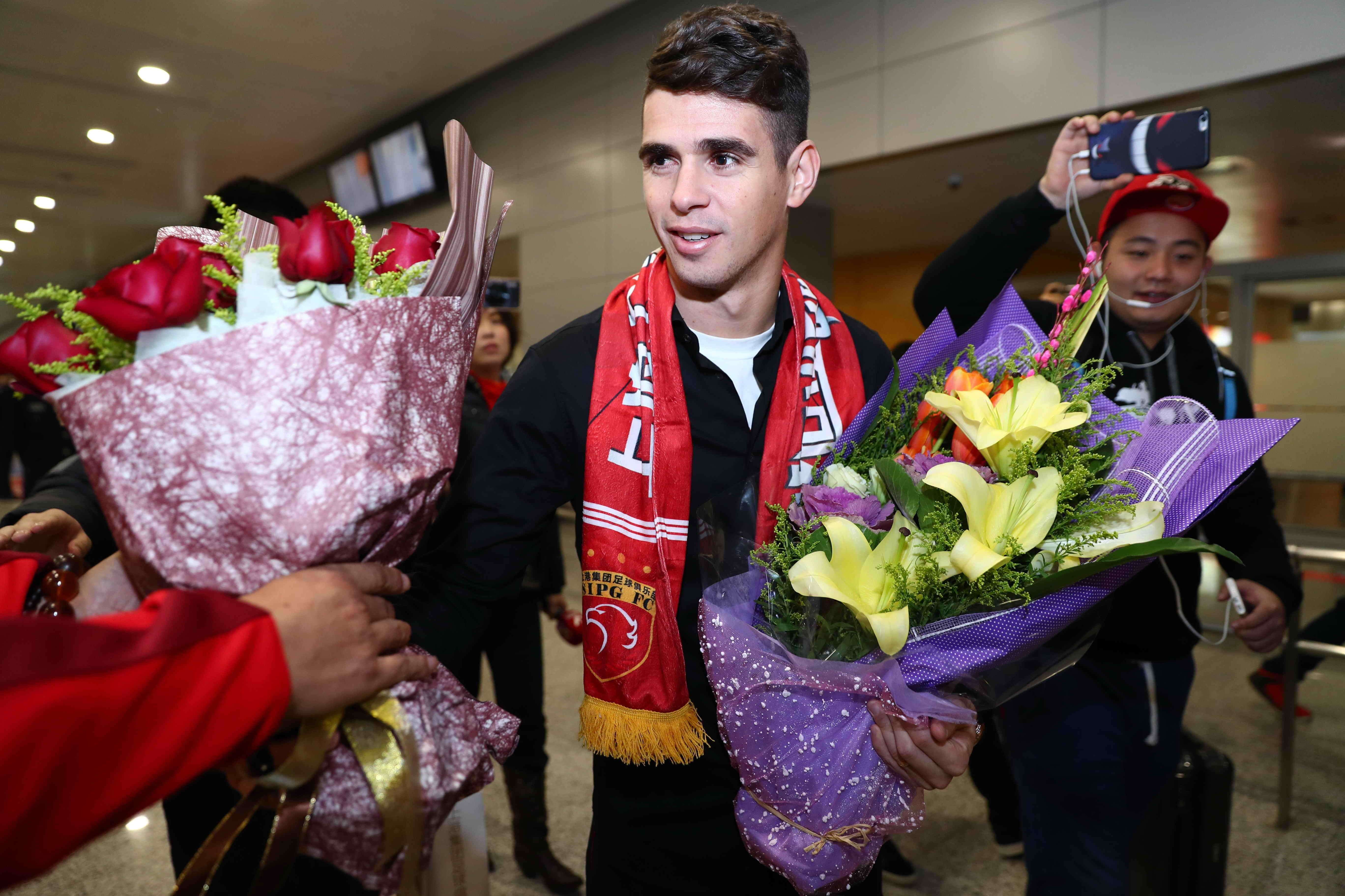 Brazilian Oscar receives flowers as he arrives in Shanghai. Photo: AFP