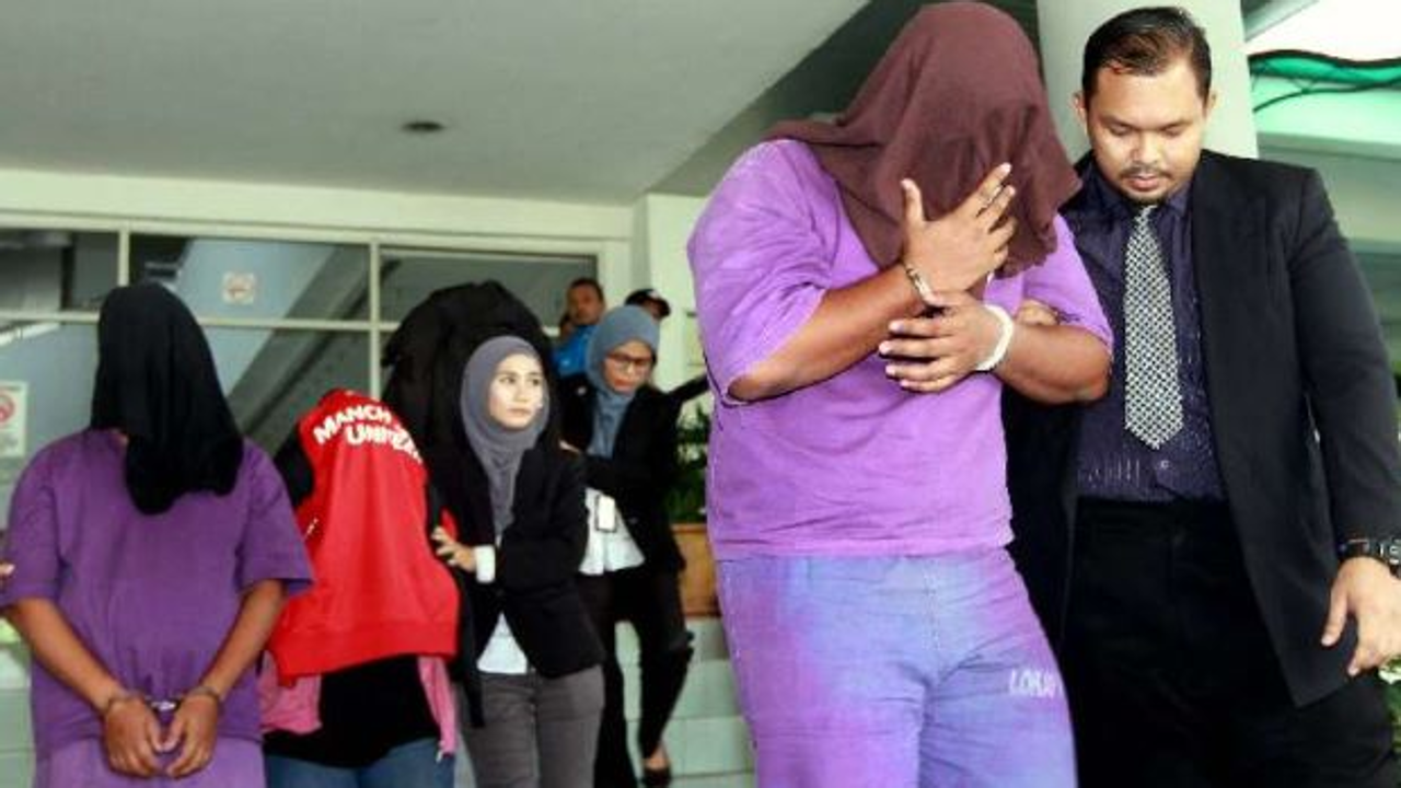 Malaysian Anti-Corruption Commission officers escorting four immigration officers out from the Shah Alam magistrate’s court after they were remanded for six days. Photo: KK SHAM/The Star