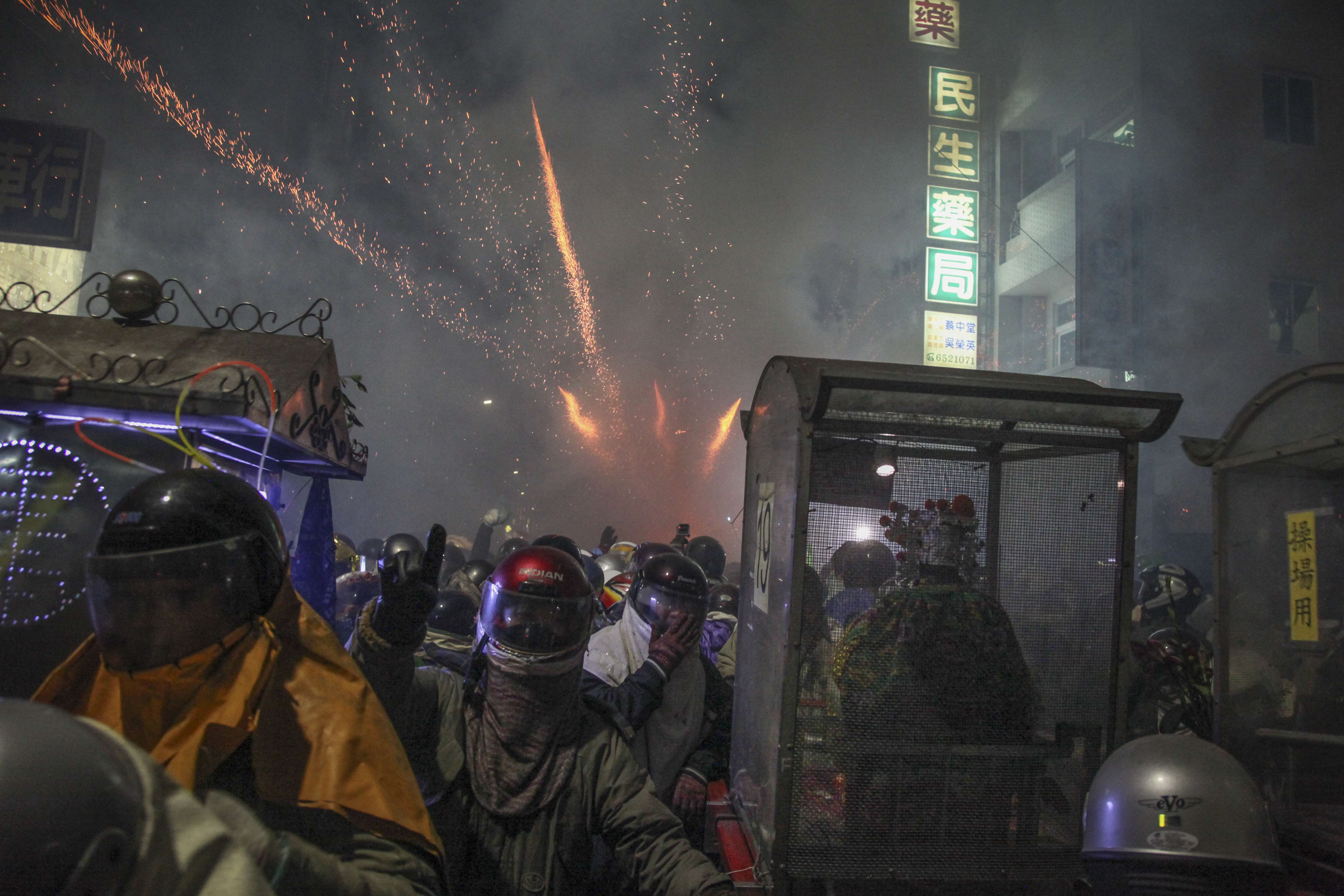 Statues of gods are carried on litters while “beehives” explode in the background. Pictures: Paul Ratje