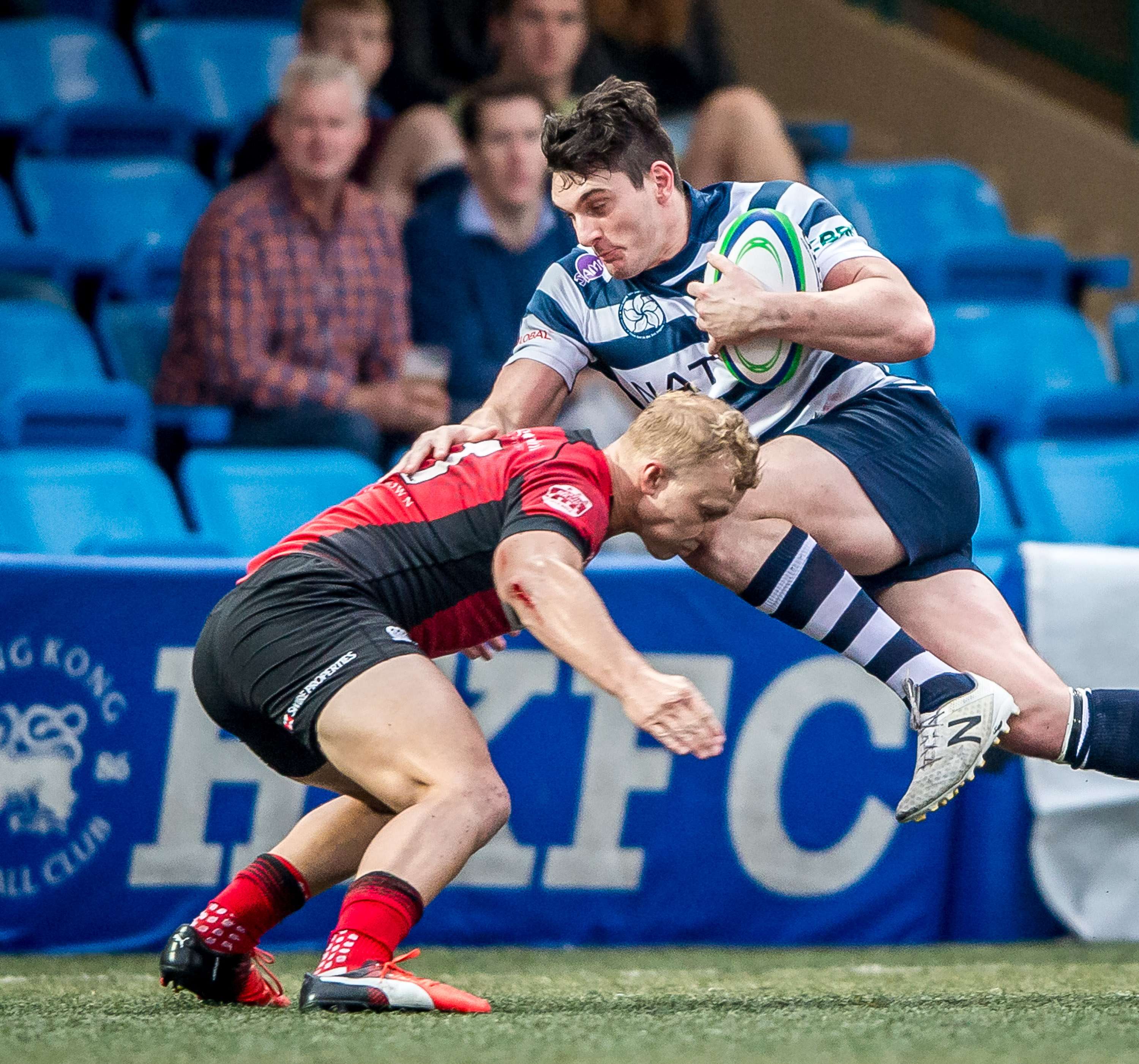 HKFC’s Charlie Higson-Smith is tackled by Max Woodward in the Hong Kong Premiership on Saturday. Photo: HKRU