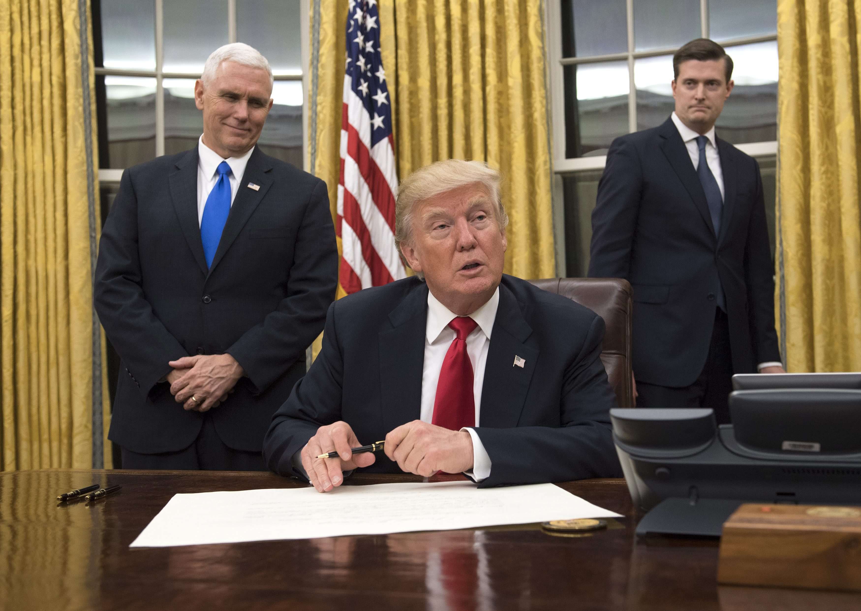 US President Donald Trump (centre) sits in the Oval Office at the White House after his inauguration on Friday. Photo: EPA