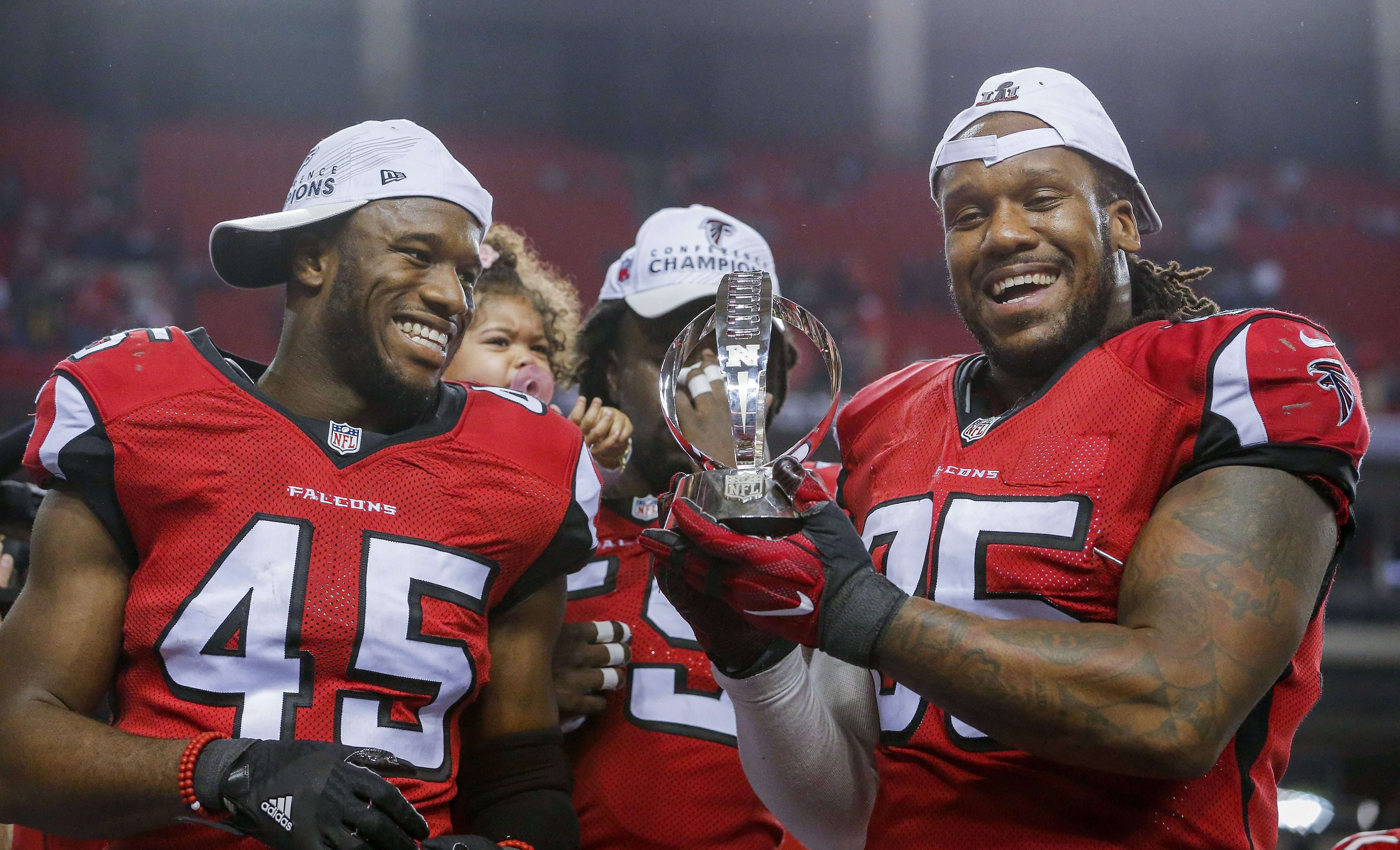 Atlanta Falcons linebacker Deion Jones (left) and Atlanta Falcons defensive tackle Jonathan Babineaux hold the NFC Championship Trophy after the Falcons defeated the Green Bay Packers in the NFC Championship game. Photo: EPA