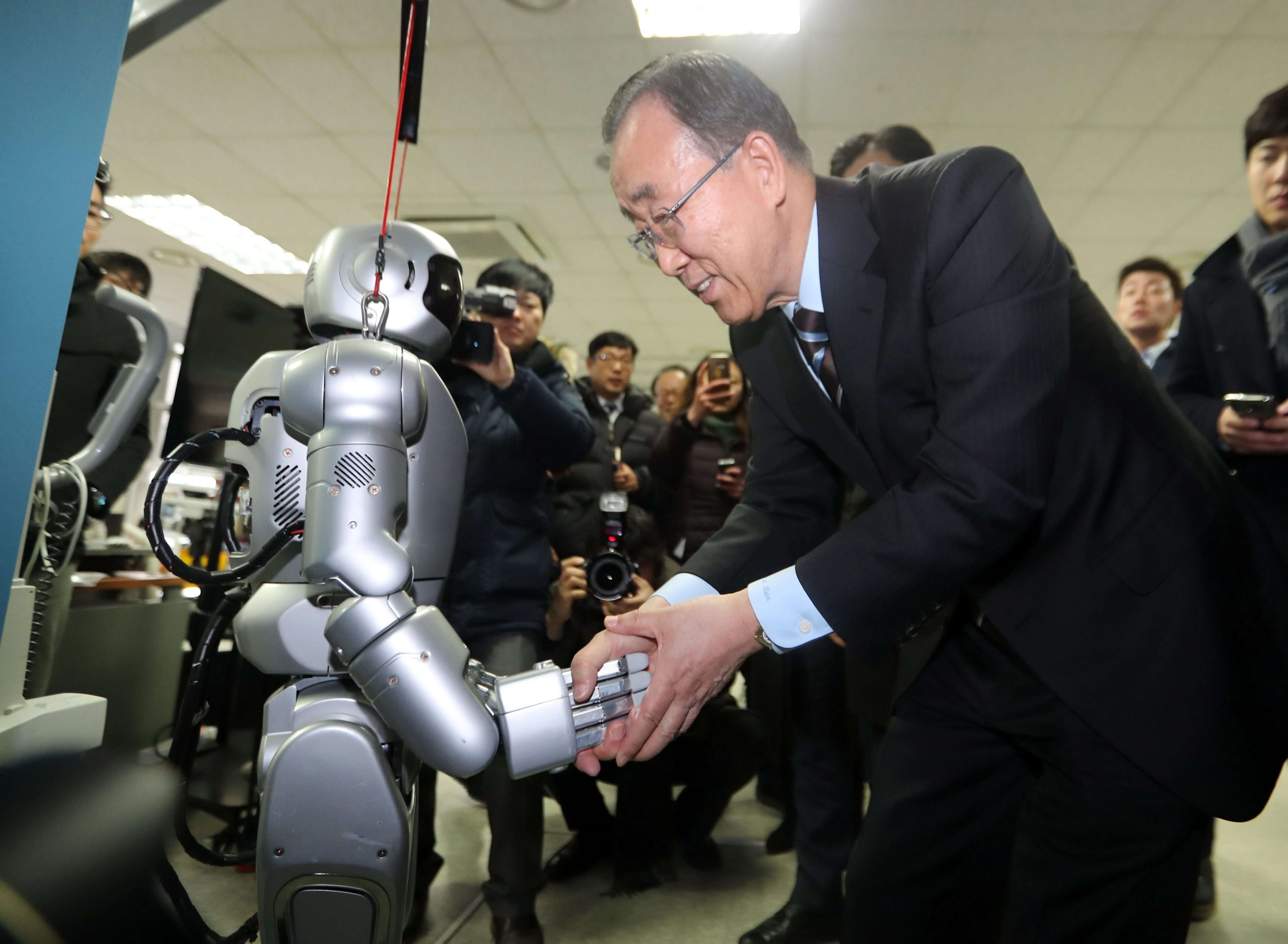Former UN secretary general Ban Ki-moon shakes hands with Hubo, a humanoid robot, during his visit to the Korea Advanced Institute of Science and Technology. Photo: EPA