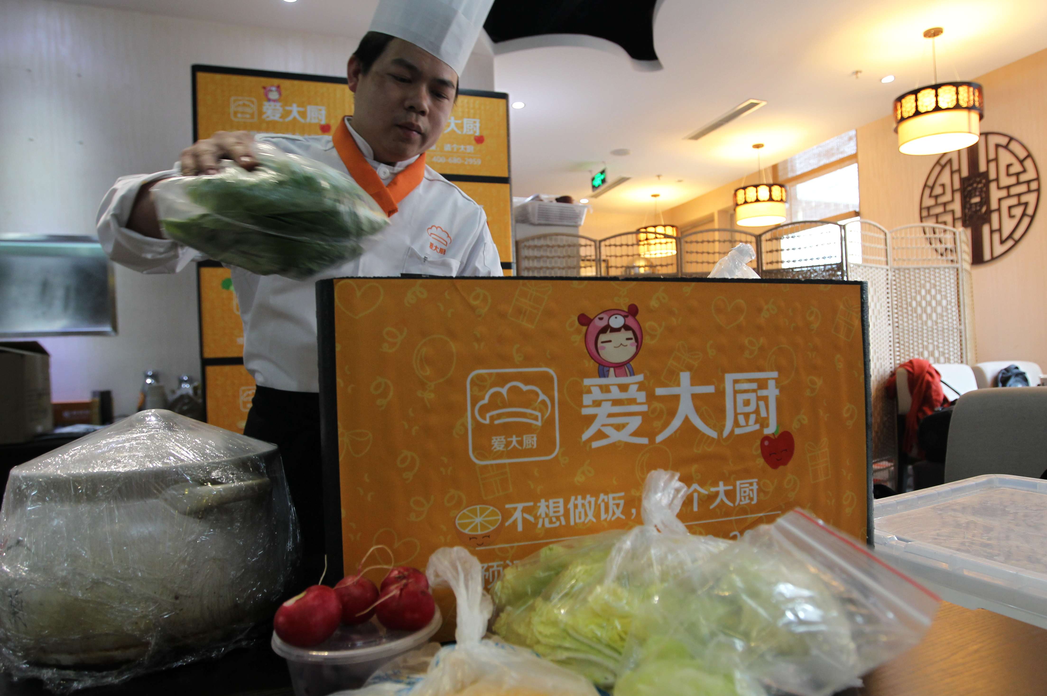 Qin Zhanwen, a chef for idachu, a Beijing-based mobile service to book chefs to cook at home, prepares the ingredients before heading out to a customer's home to cook. Photo: Simon Song