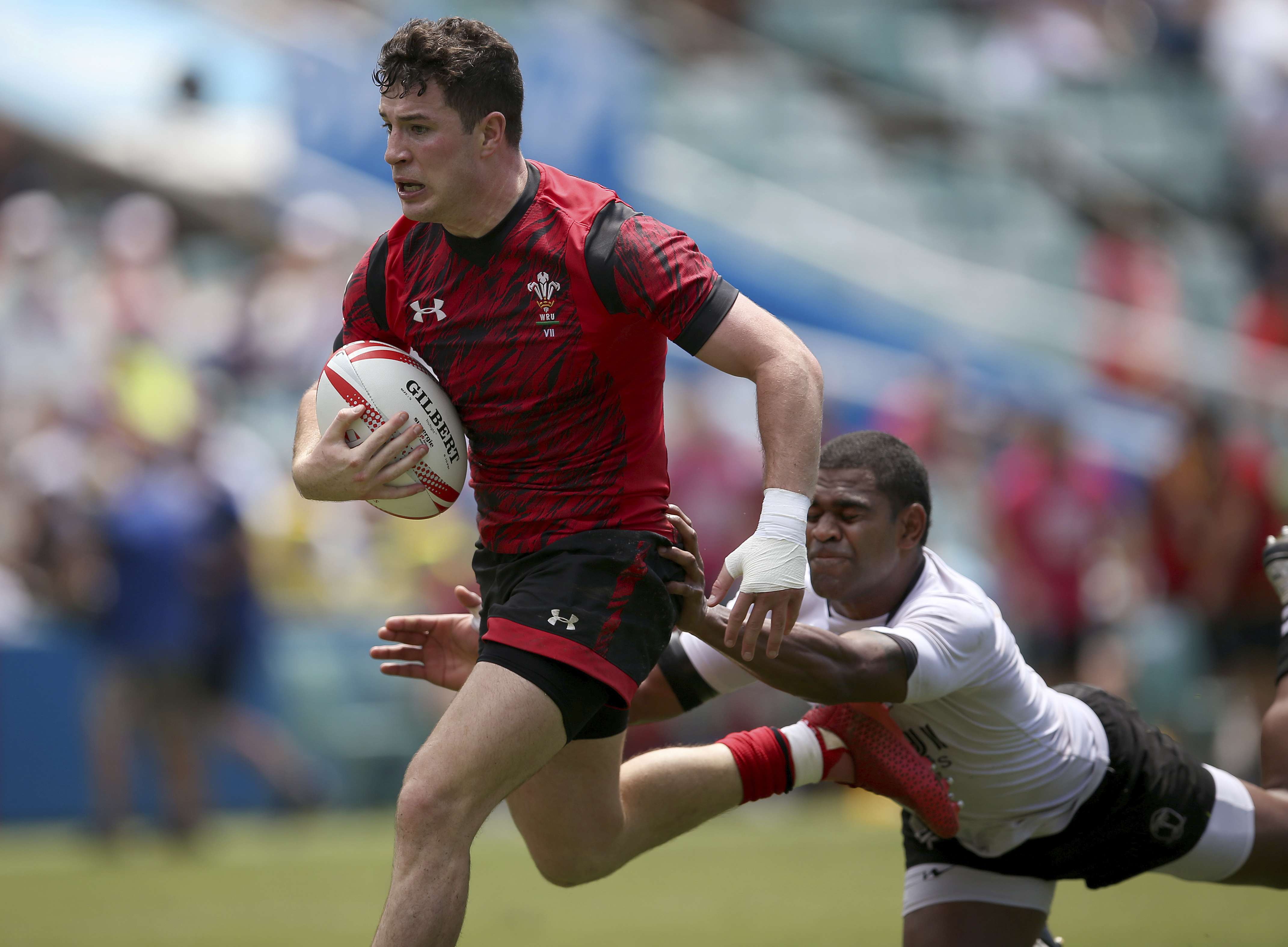 Wales' Owen Jenkins, left, runs through a tackle from Fiji's Vatemo Ravouvou to score a try. Photo: AP