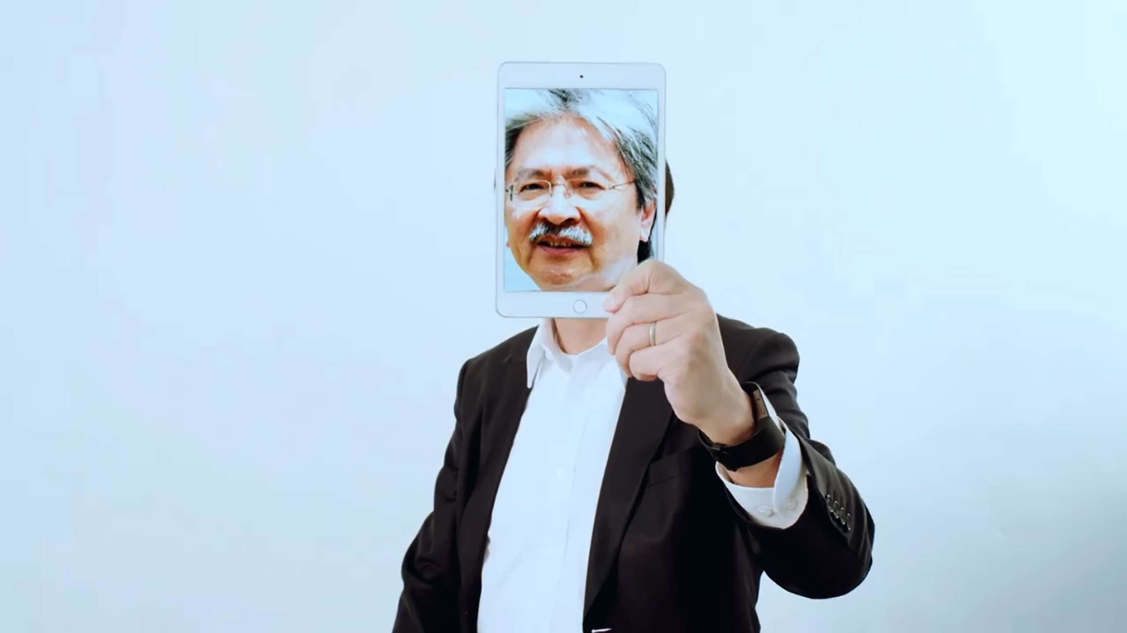 At the start of the video, Mak Chai-kwong held an image of former finance chief John Tsang in front of his own face. Photo: Facebook