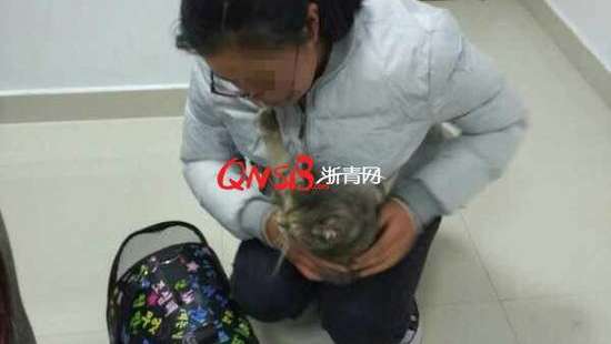 The student with her pet cat, after the animal was discovered by security guards at the train station in Lishui. Photo: Handout