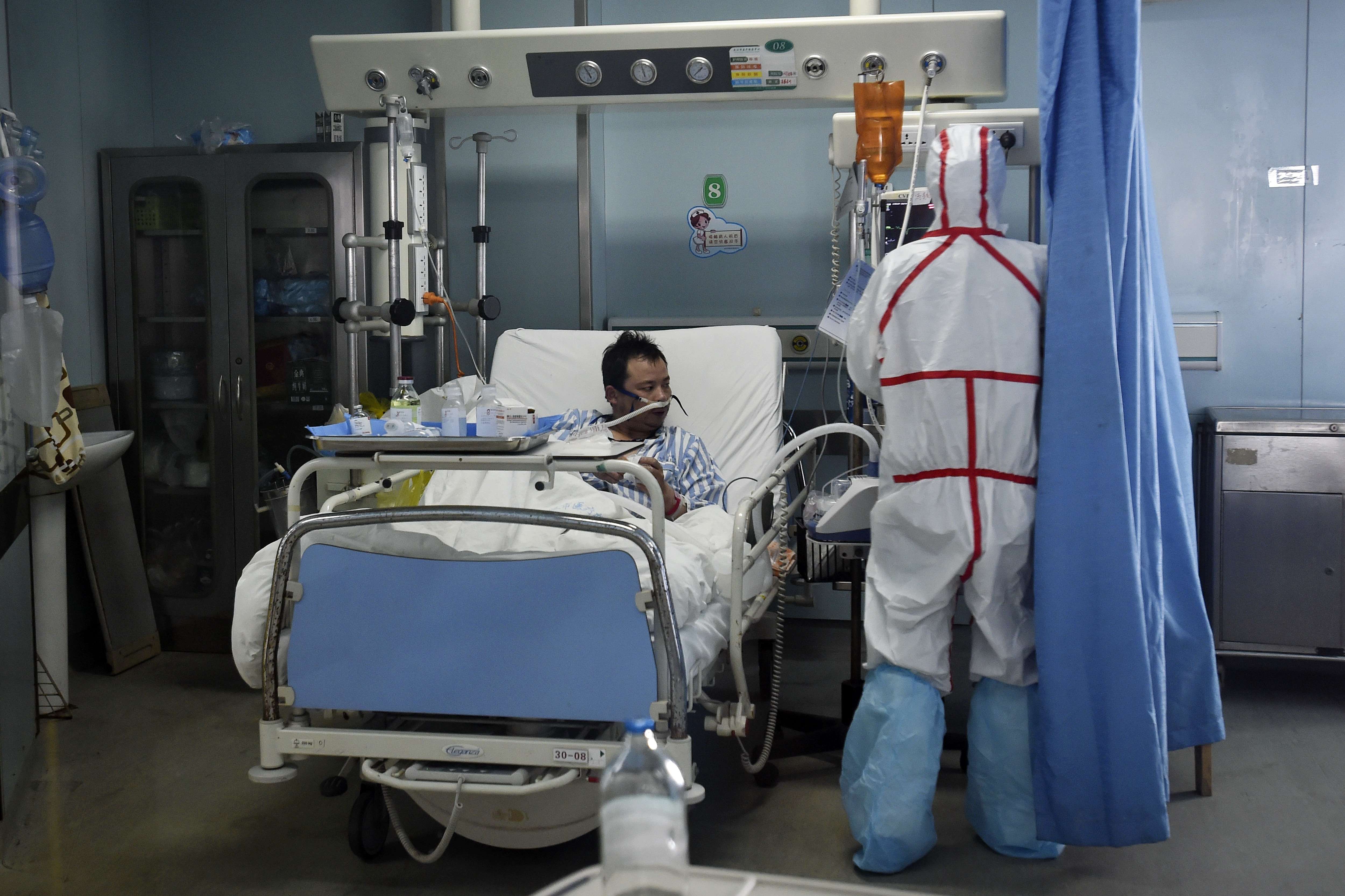 A patient infected with the bird flu virus in Wuhan in Hubei province is pictured on Sunday receiving treatment from a medical worker. Photo: AP