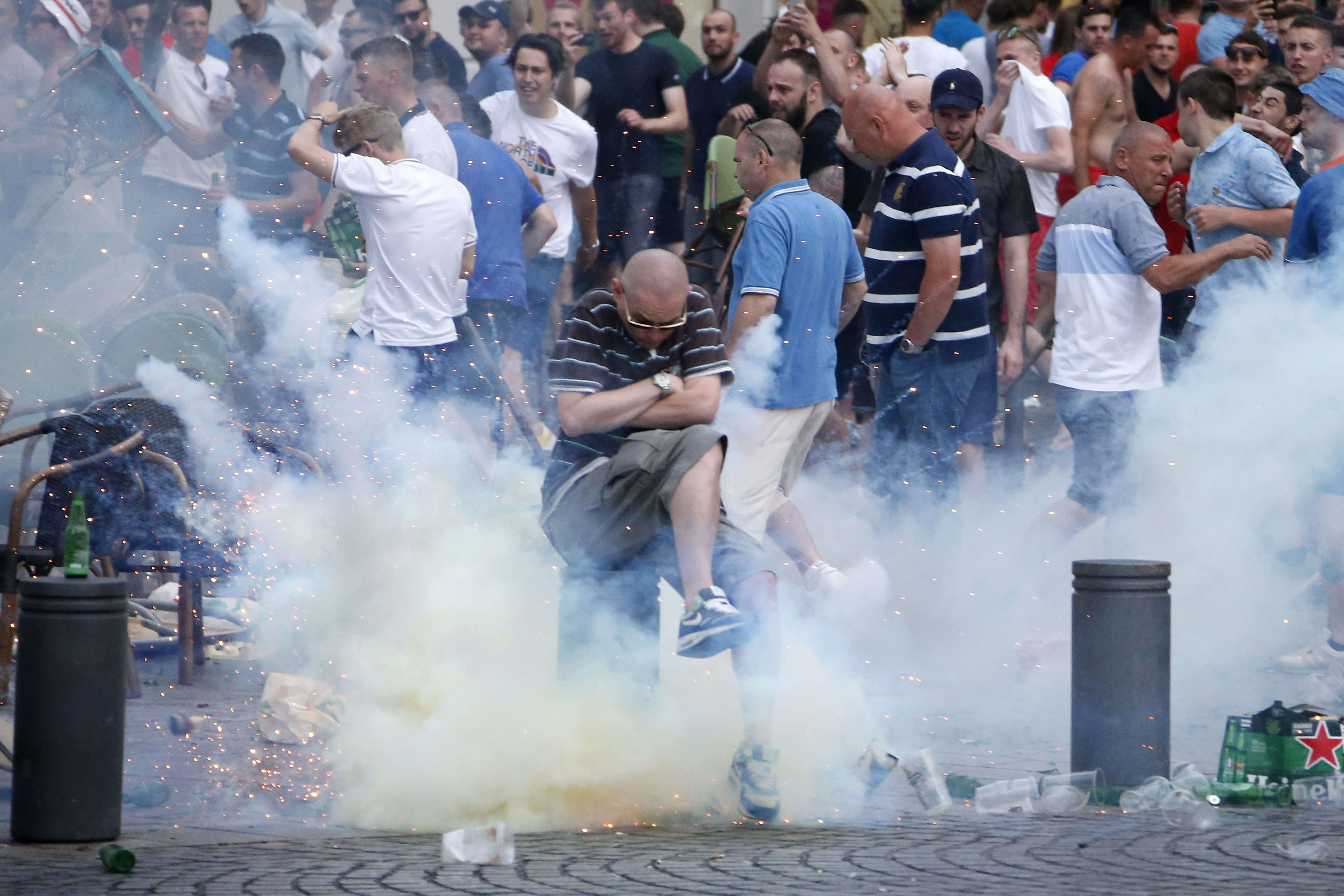 An England fan evades a smoke grenade thrown by riot French police during clashes with Russian supporters. Photo: EPA