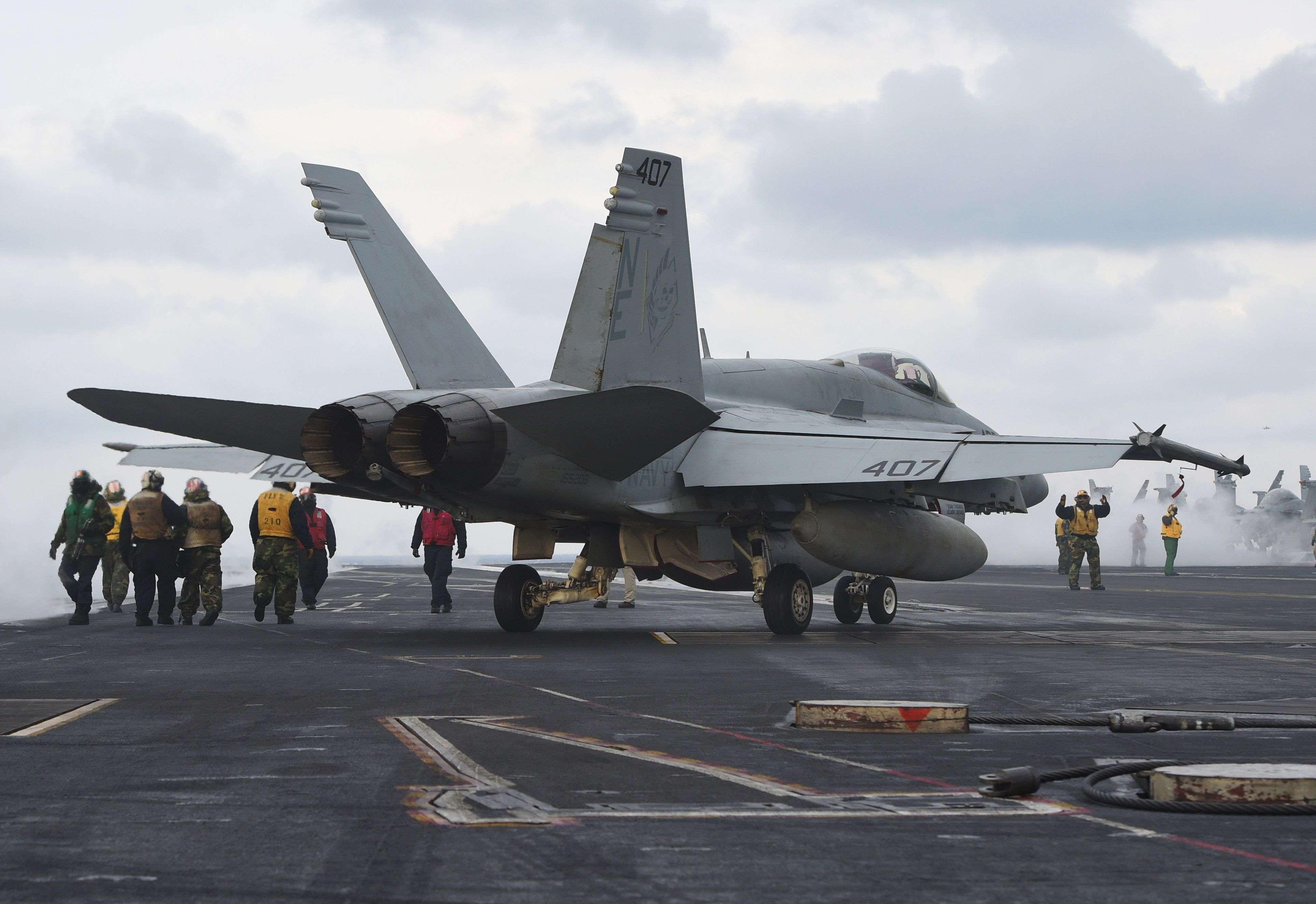 US Navy flight crew members stand near a single-seater F/A-18C Hornet fighter jet on the deck of the Nimitz-class aircraft carrier USS Carl Vinson. The nuclear-powered carrier arrived in South Korea on Wednesday to participate in an ongoing joint military exercise, the US navy said. Photo: AFP