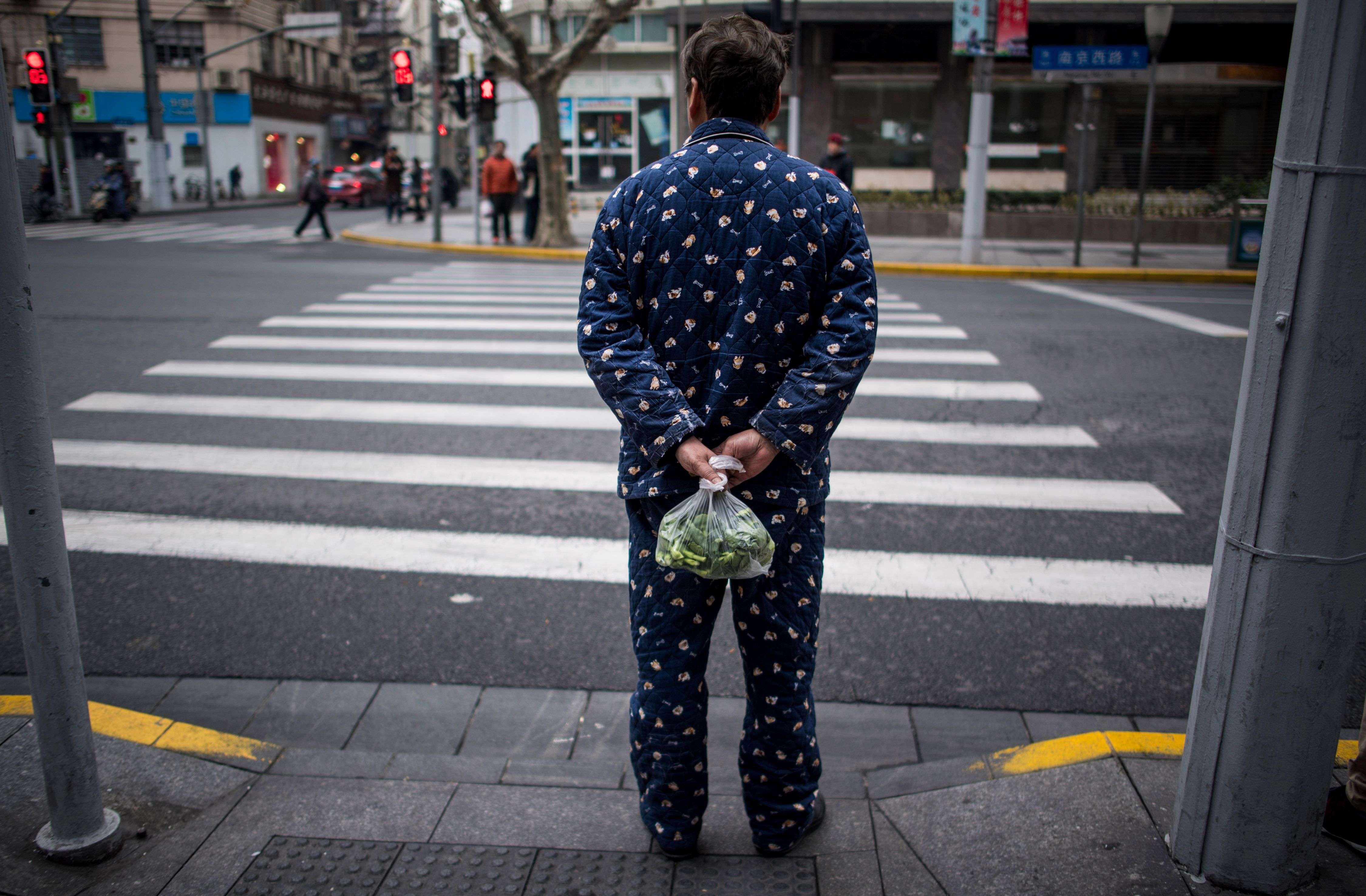 A man wearing pyjamas waits to cross the road in Shanghai. Leading the globe requires strength, and strength derives from real self-confidence which, in turn, is demonstrated in an open attitude to others. Photo: AFP