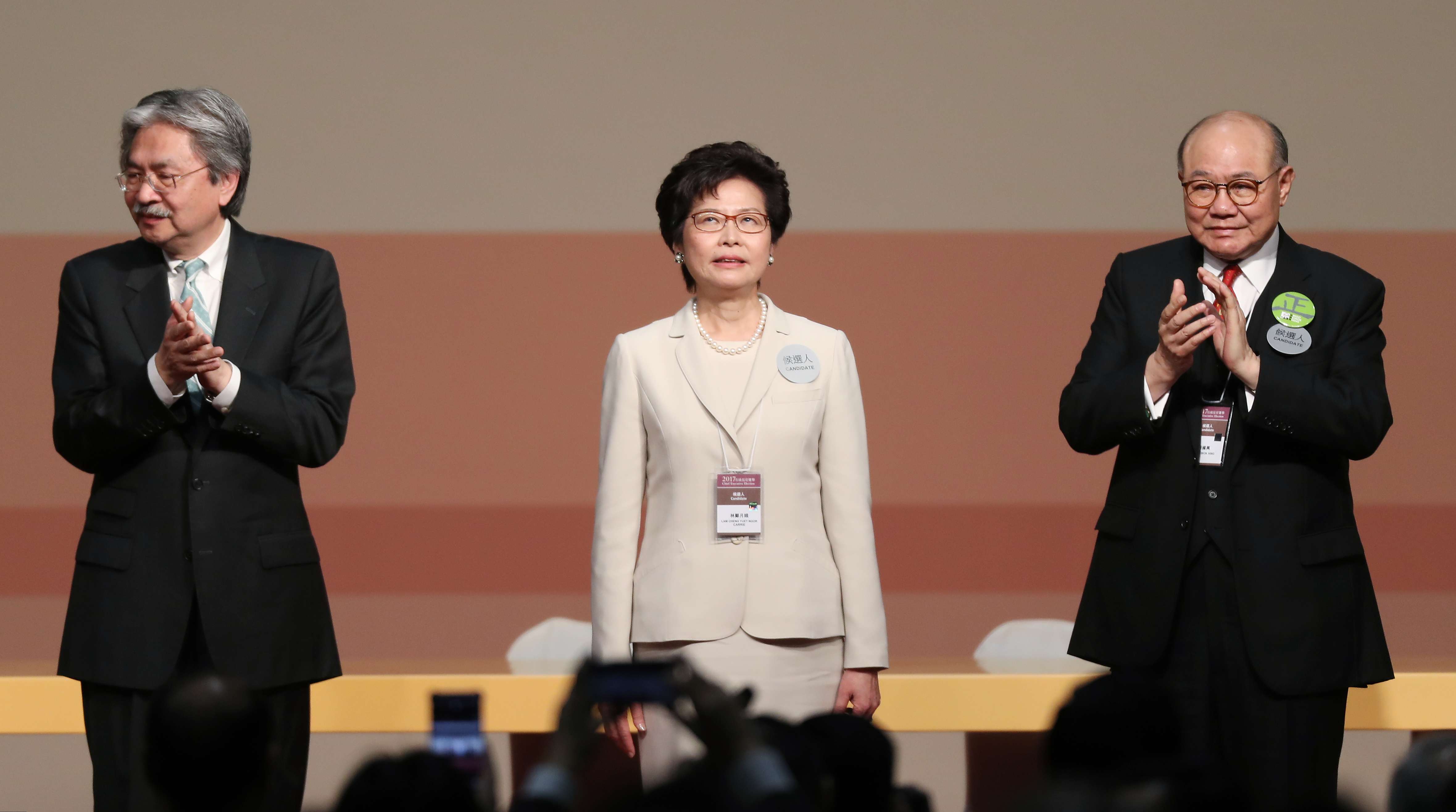 Carrie Lam is applauded by her defeated rivals, John Tsang (left) and Woo Kwok-hing. Photo: Robert Ng